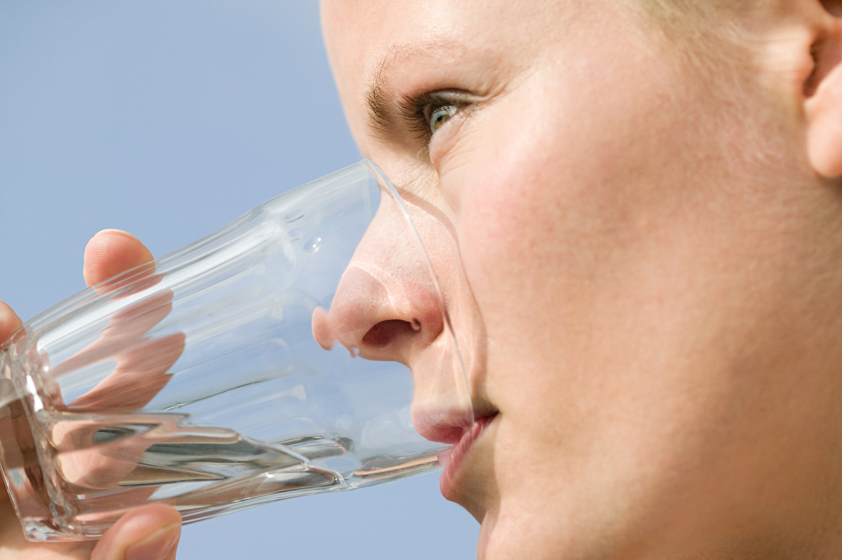 En kvinde drikker et glas vand.
