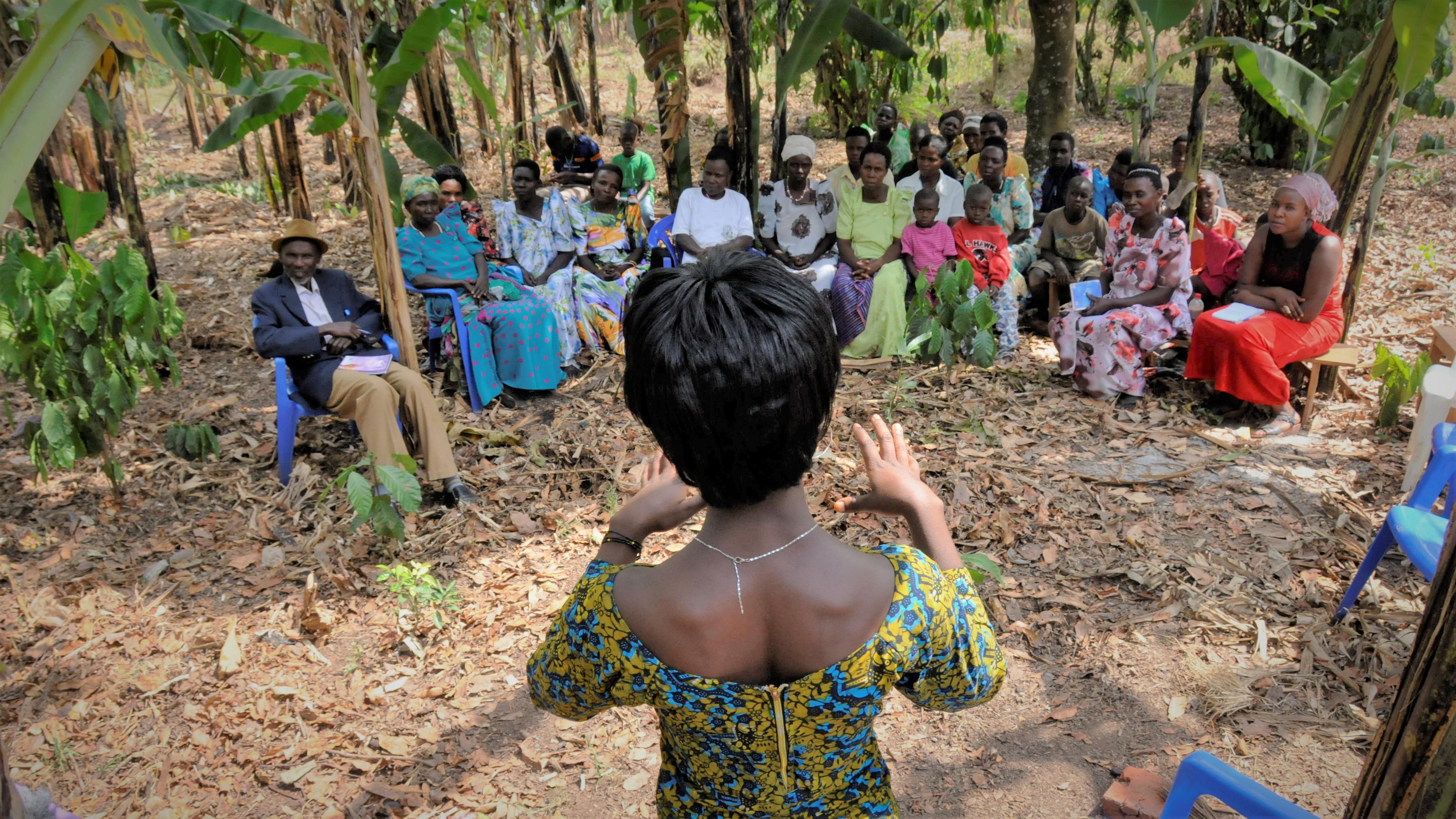 En kvinde underviser en gruppe landmænd i Uganda