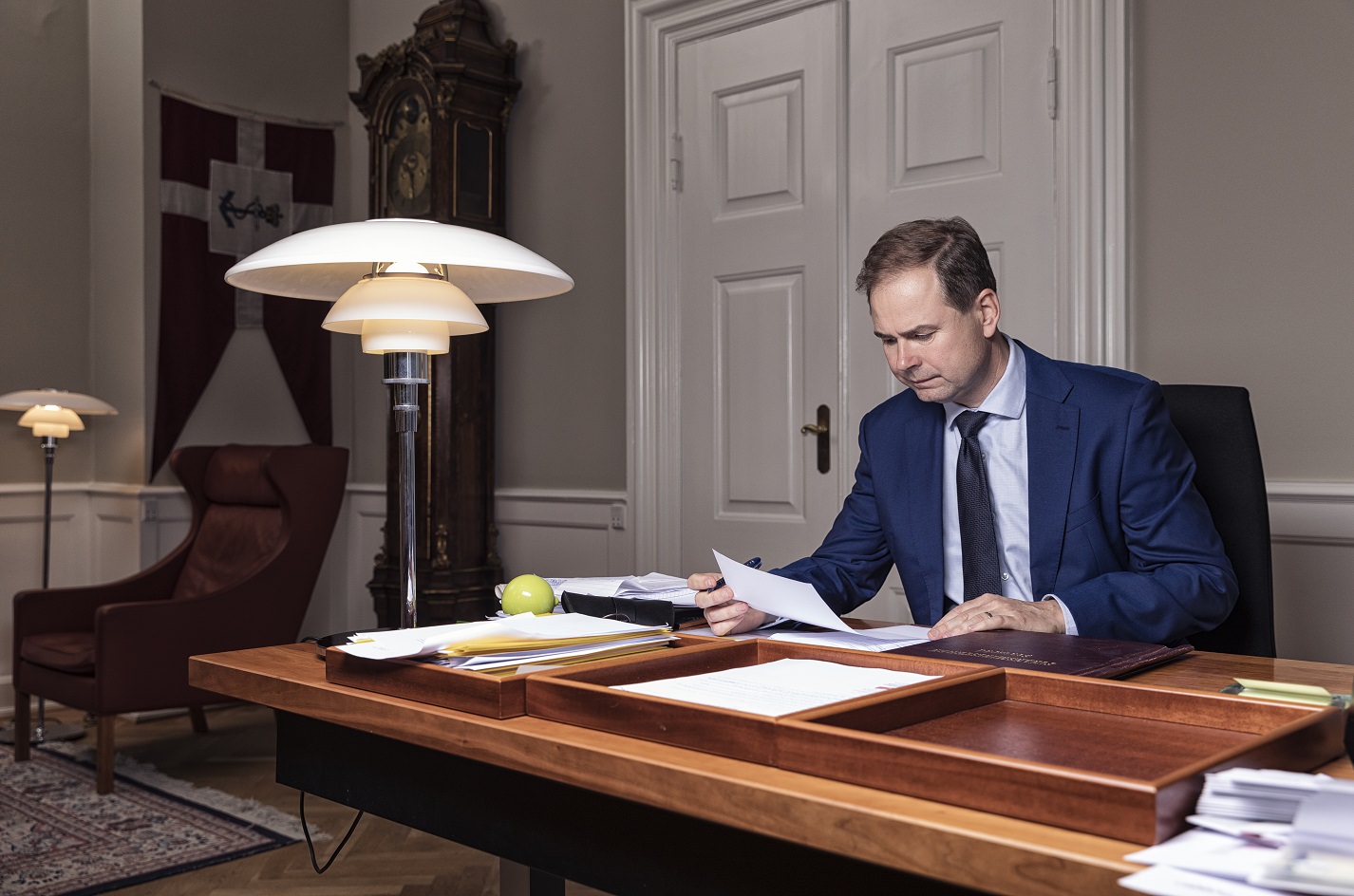 Finansminister Nicolai Wammen sidder ved sit skrivebord og læser et stykke papir