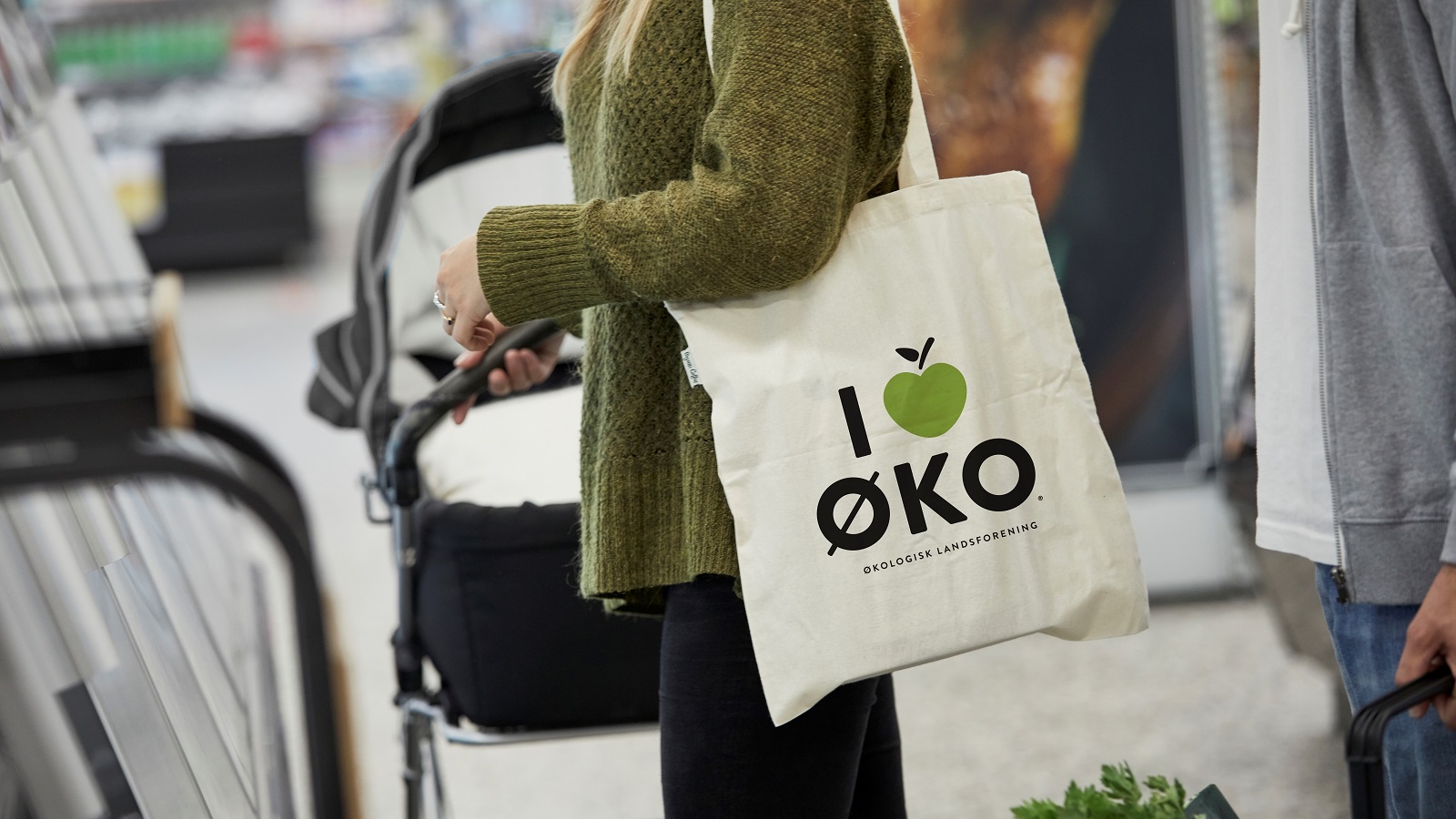 Kunde forlader butik med I love øko-mulepose med varer