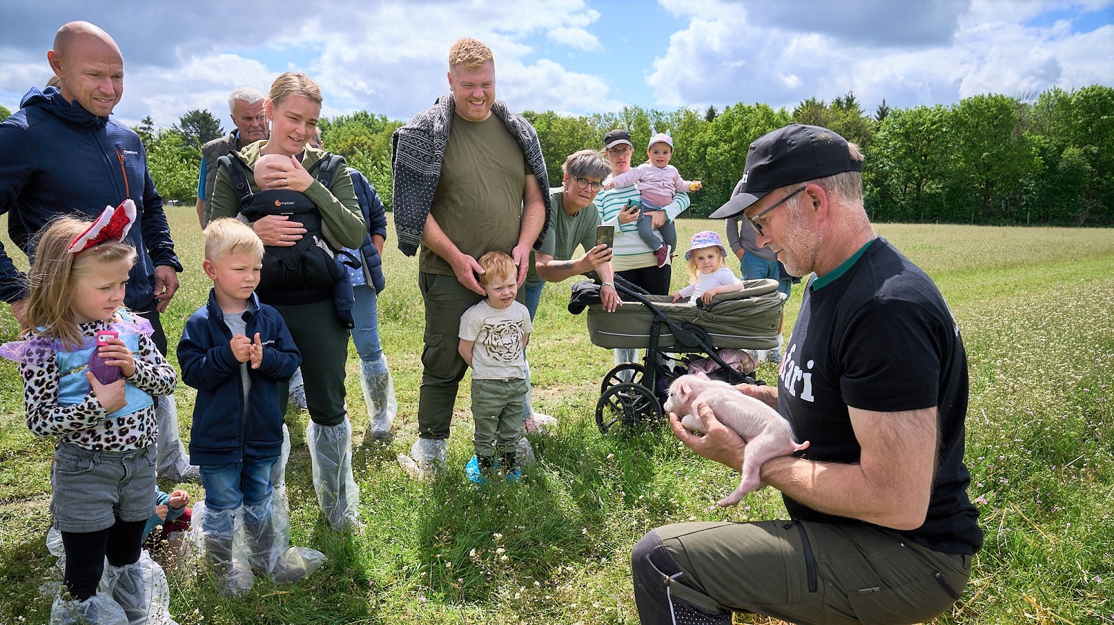 Nicolaj Pedersen viser en lille nyfødt gris frem for børnene ved Sofari
