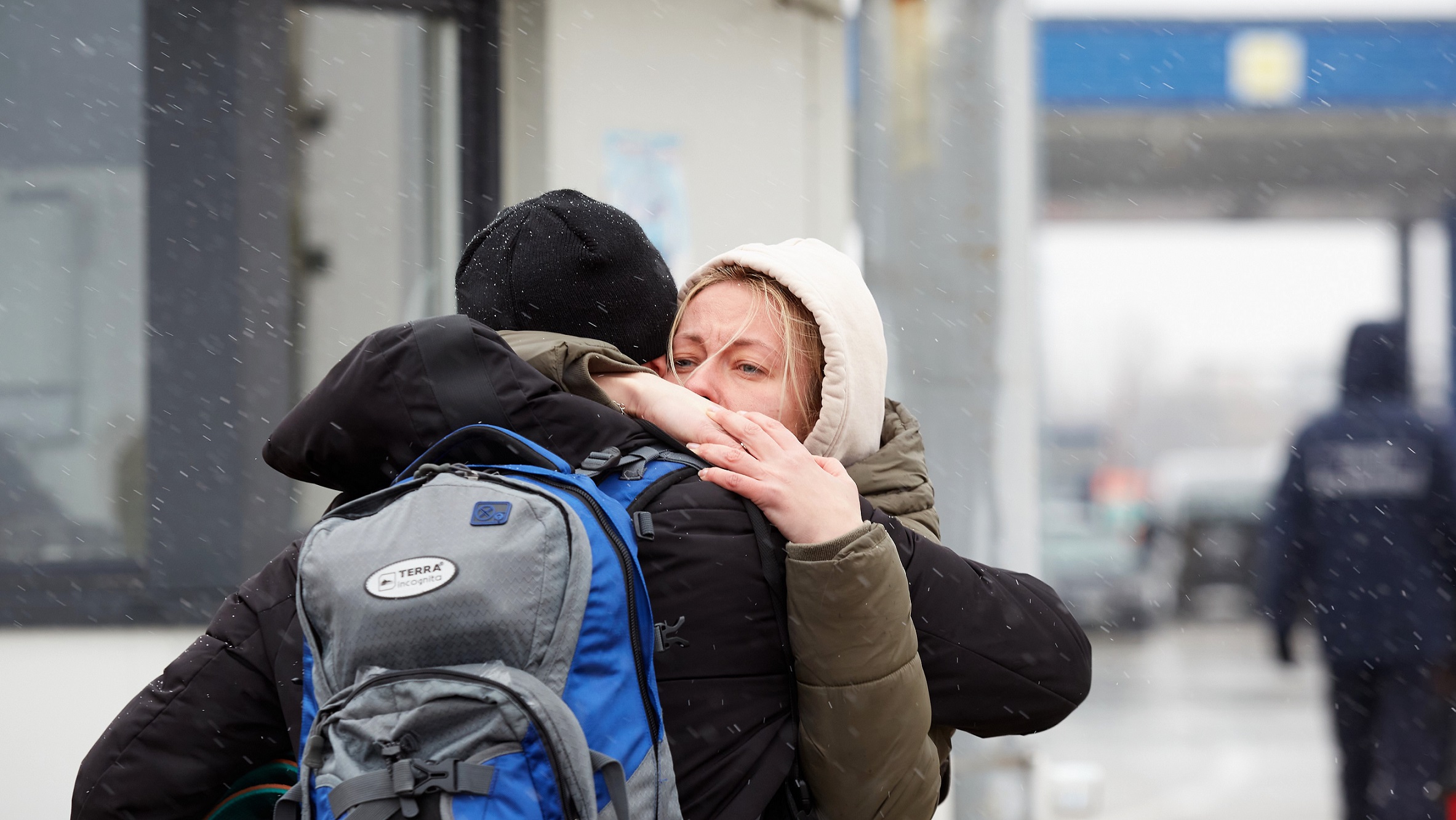 To personer krammer hinanden i snevejr ved den ukrainske grænse