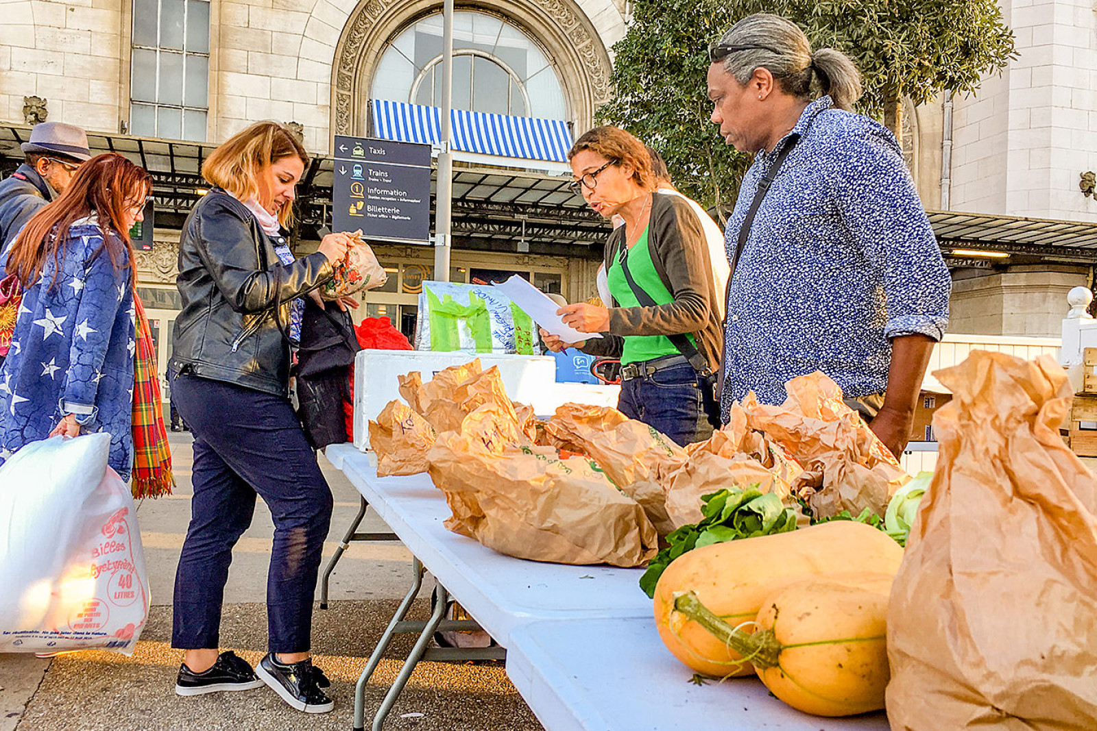 En handlende er ved at købe mad på et madmarked i Paris.