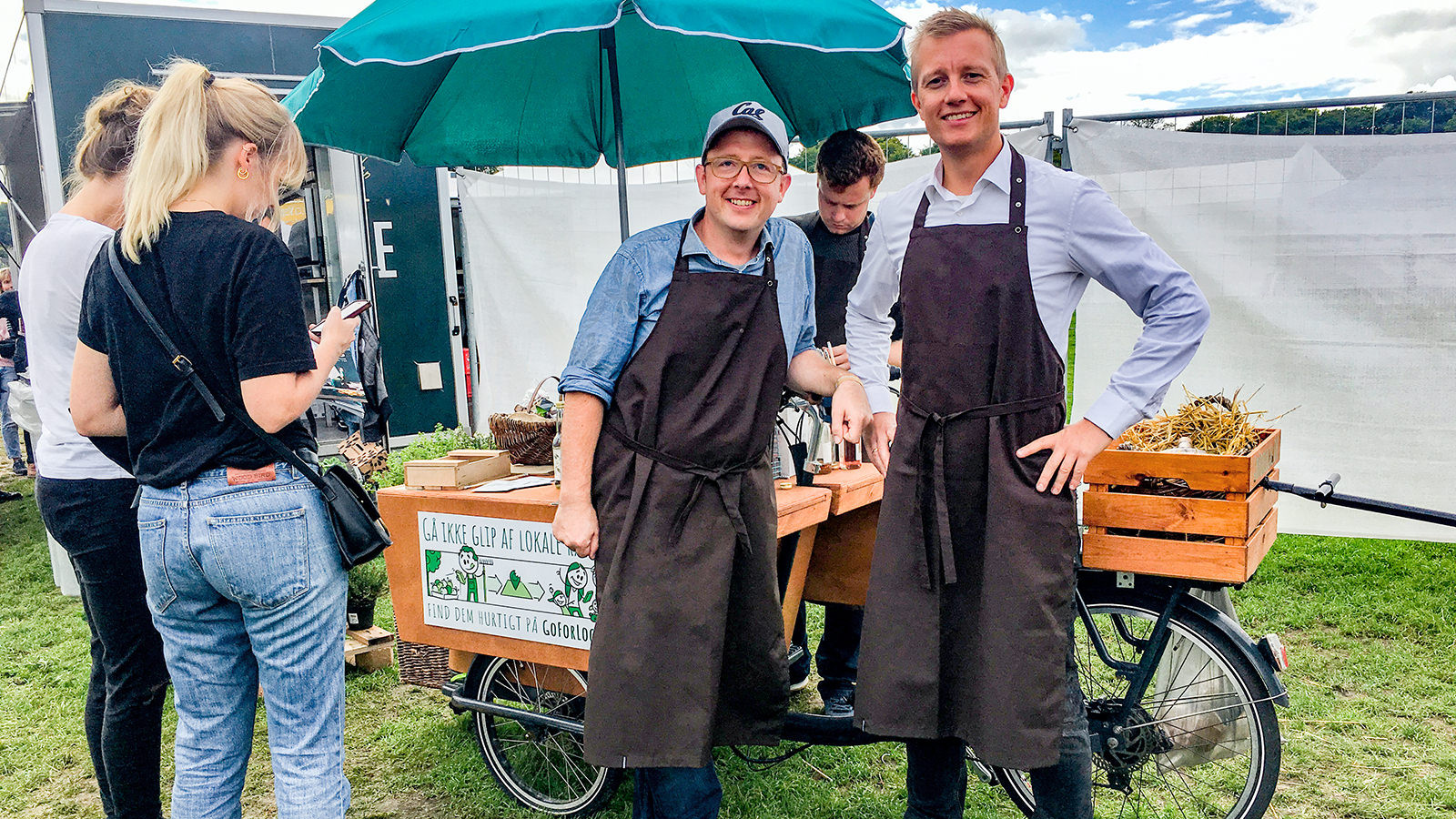 Niels Reinau og Niels Høegmark - bagmændene bag Goforlocal - står foran en lille bod sat op på en ladcykel og smiler til kameraet.