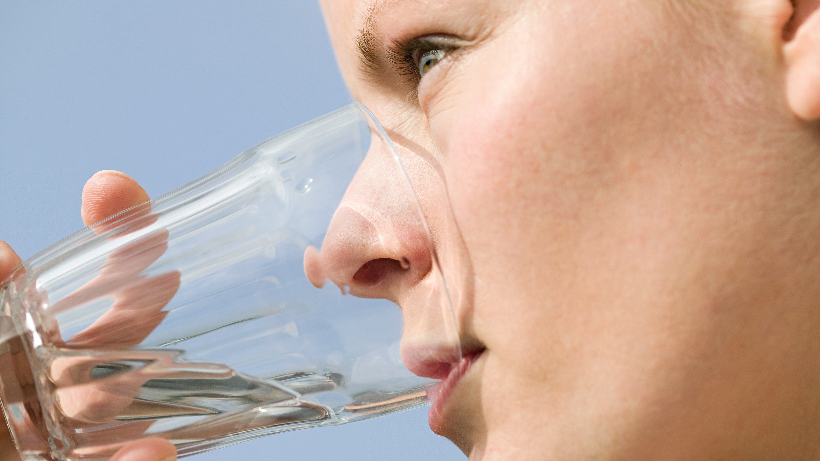 En kvinde drikker et glas vand.