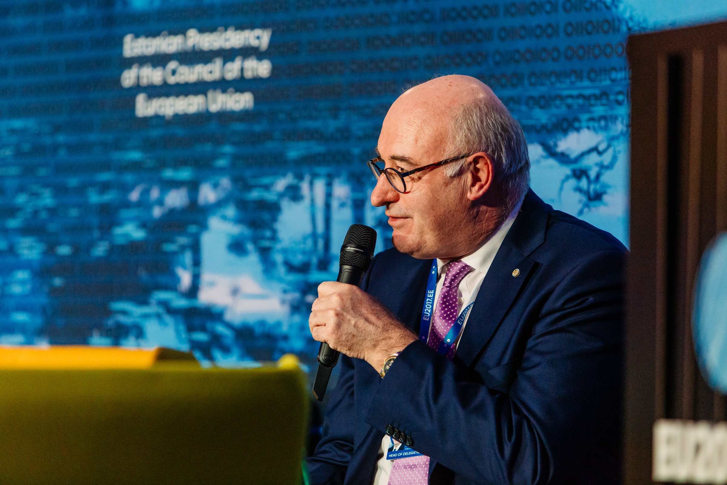 EU's landbrugskommissær, Phil Hogan, sidder med en mikrofon mod munden og taler.