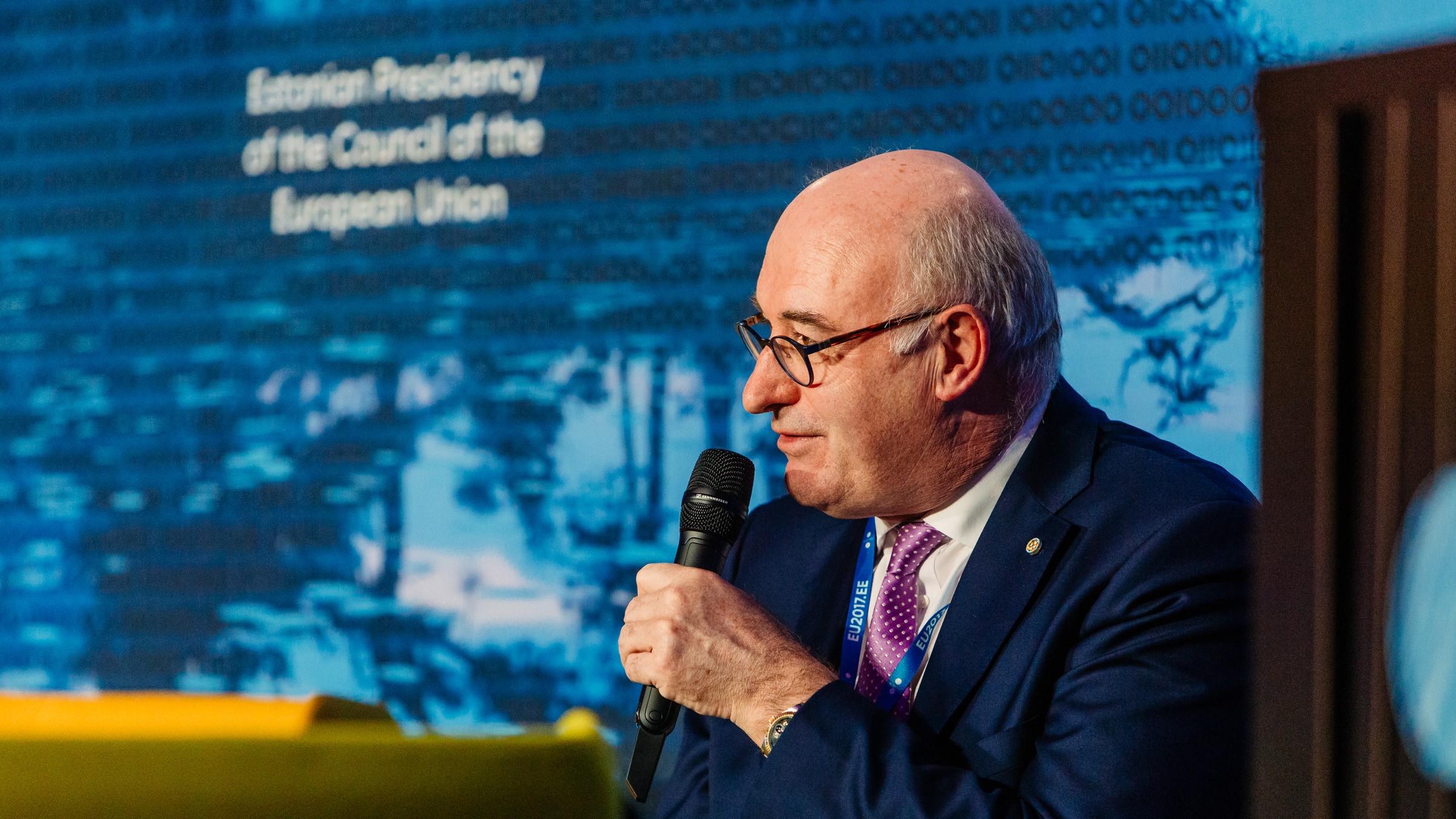 EU's landbrugskommissær, Phil Hogan, sidder med en mikrofon mod munden og taler.