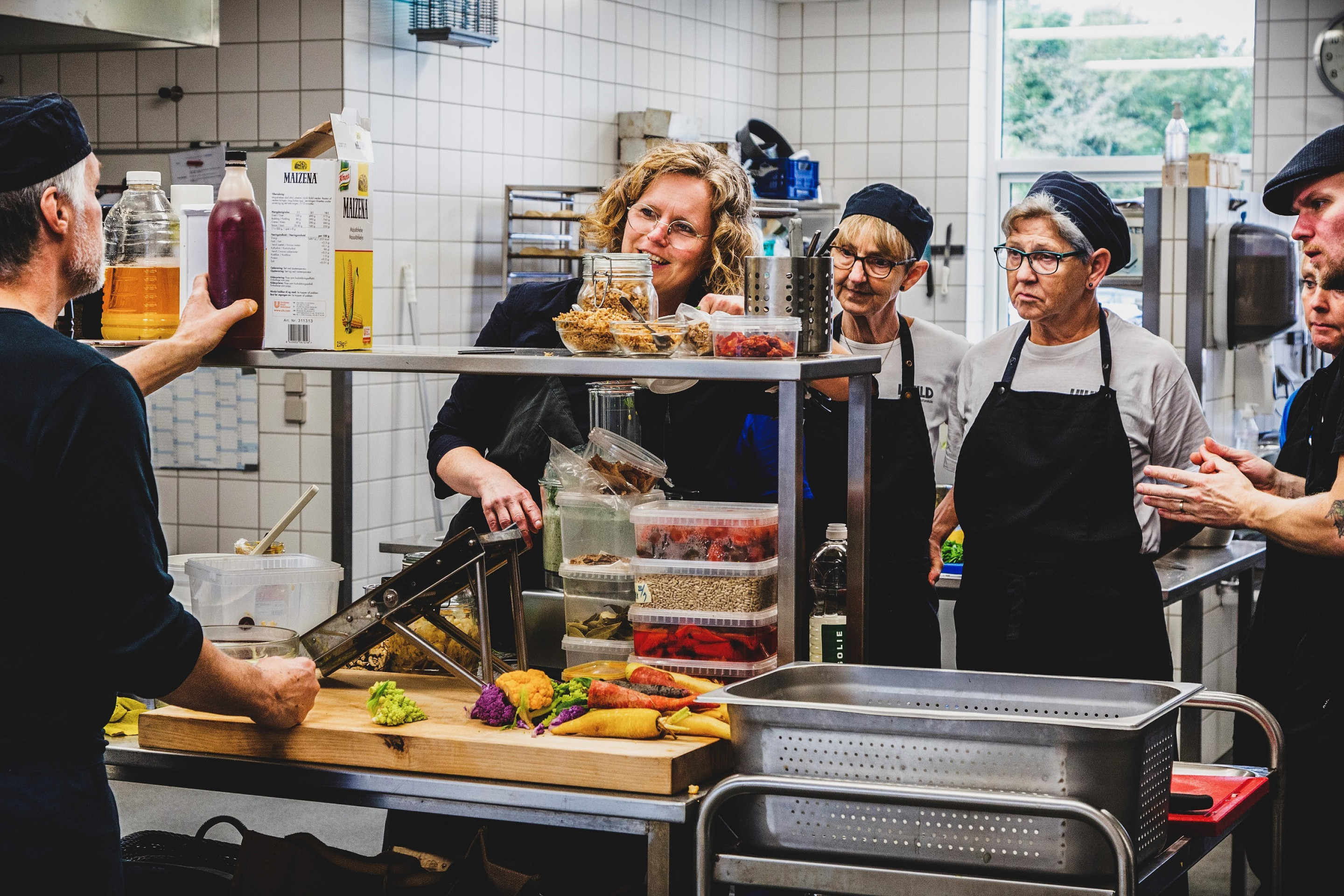 Køkkenpersonale står i køkkenet på Vivild Efterskole