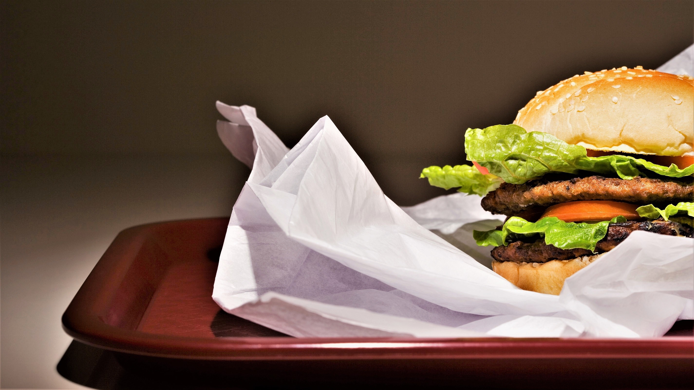 En burger er pakket ud på en bakke