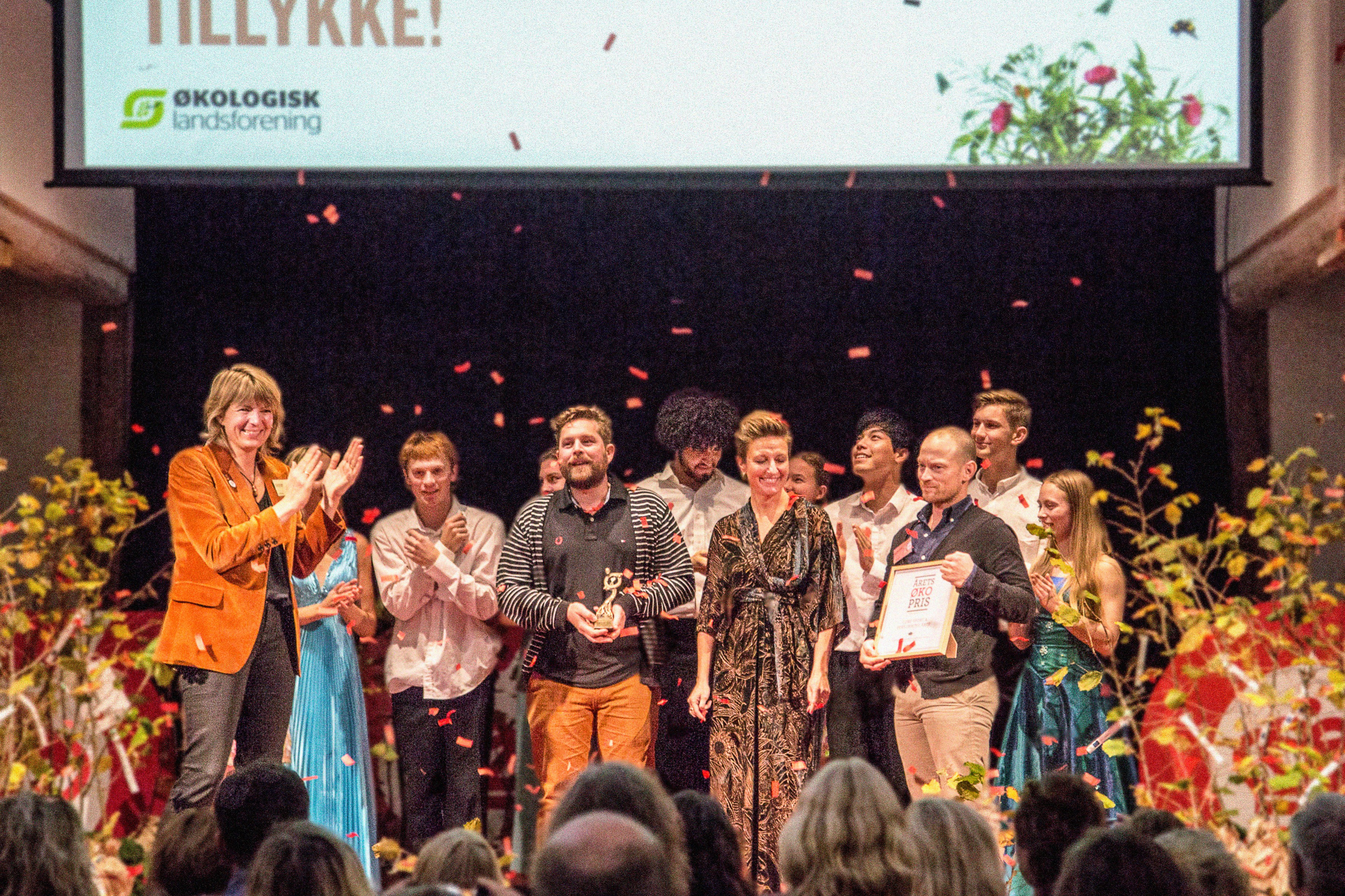 Repræsentanter fra Skolerne i Oure modtager årets Øko-Pris 2019 på scenen med Helle Borup Friberg fra Økologisk Landsforening