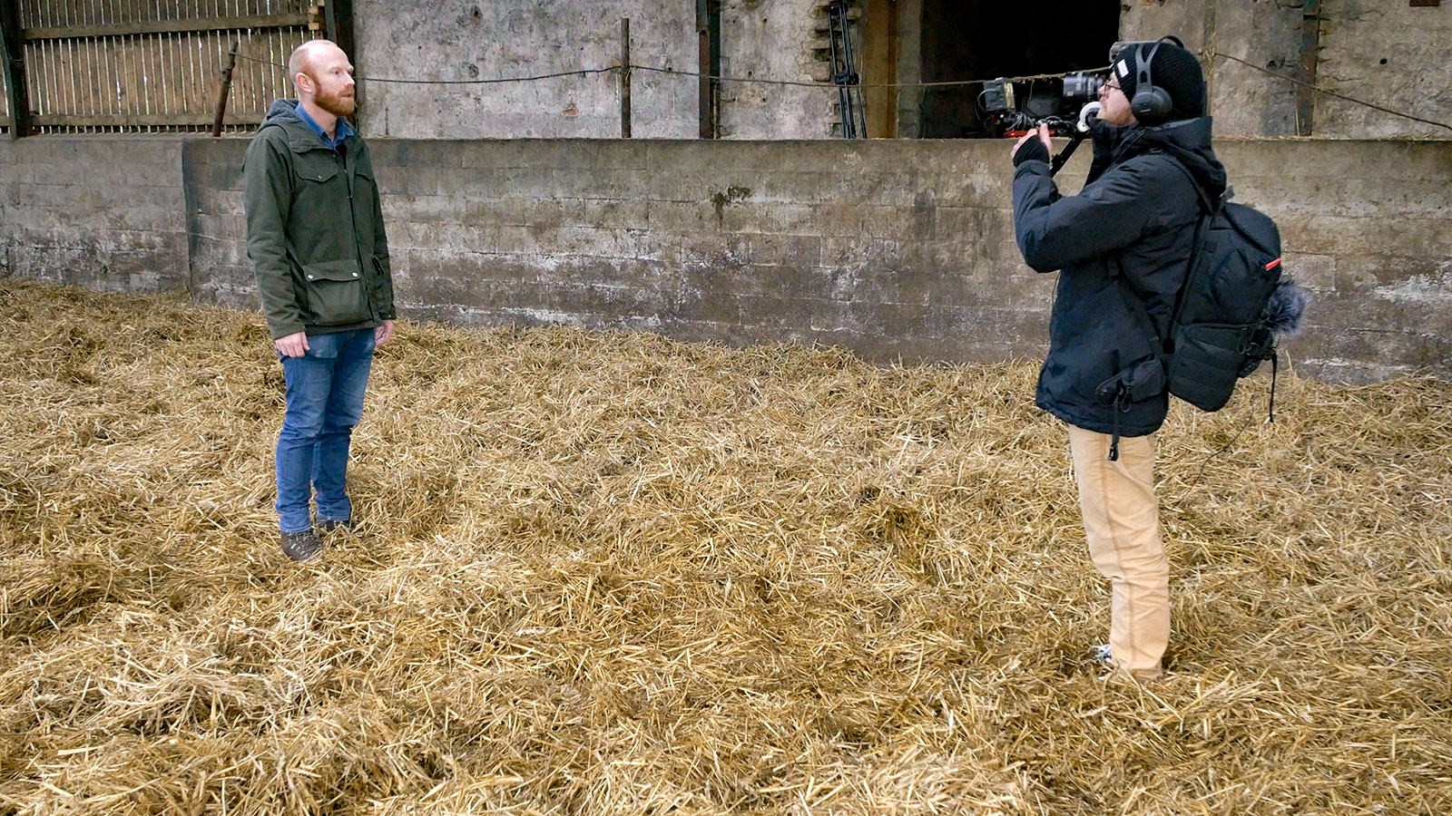Joachim Kjeldsen bliver filmet, mens han står på en bunke af halm
