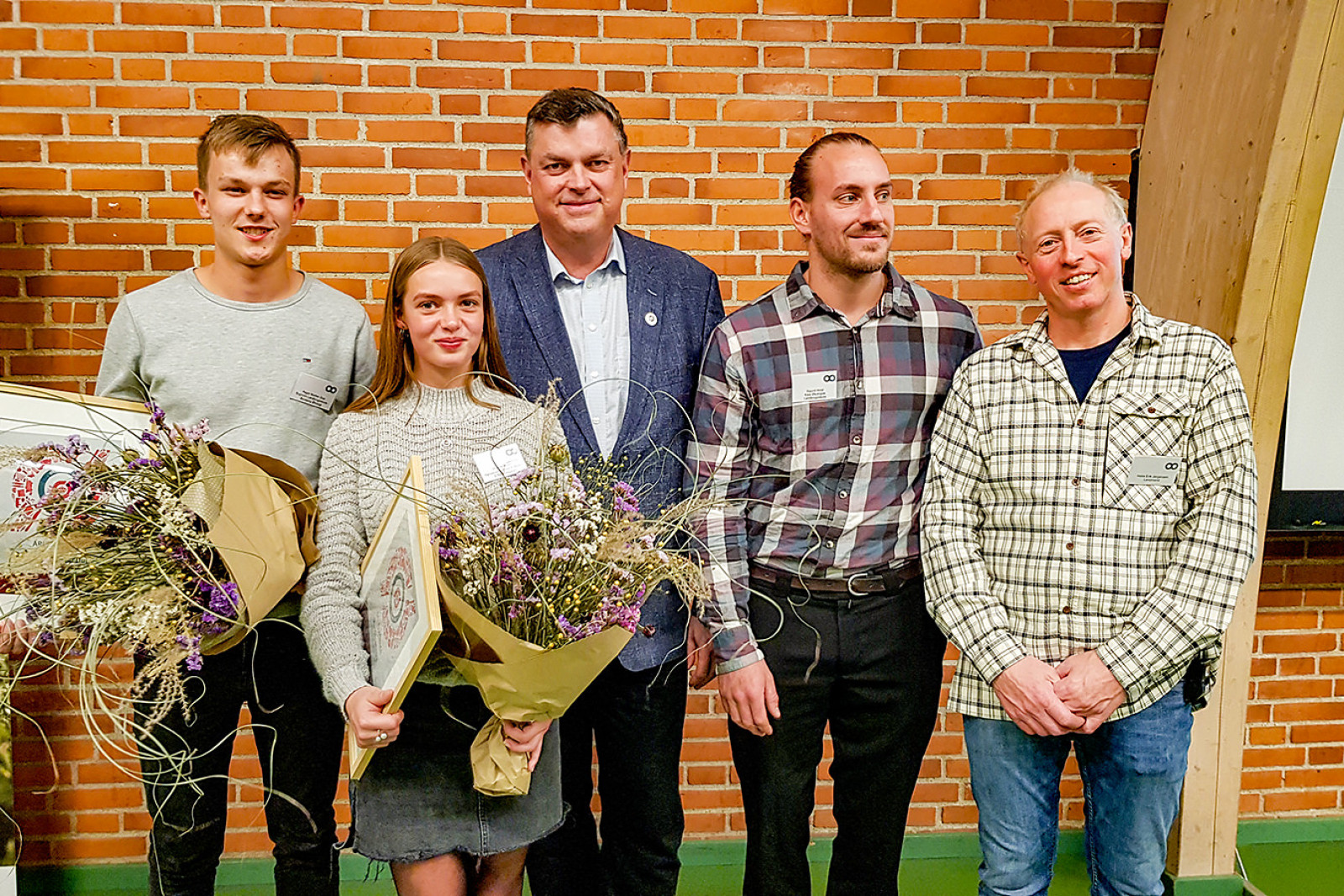 Vinderne af 'Årets øko-elev' står med blomster sammen med formanden for Økologisektionen og fødevareminister Mogens JensenFra prisoverrækkelsen