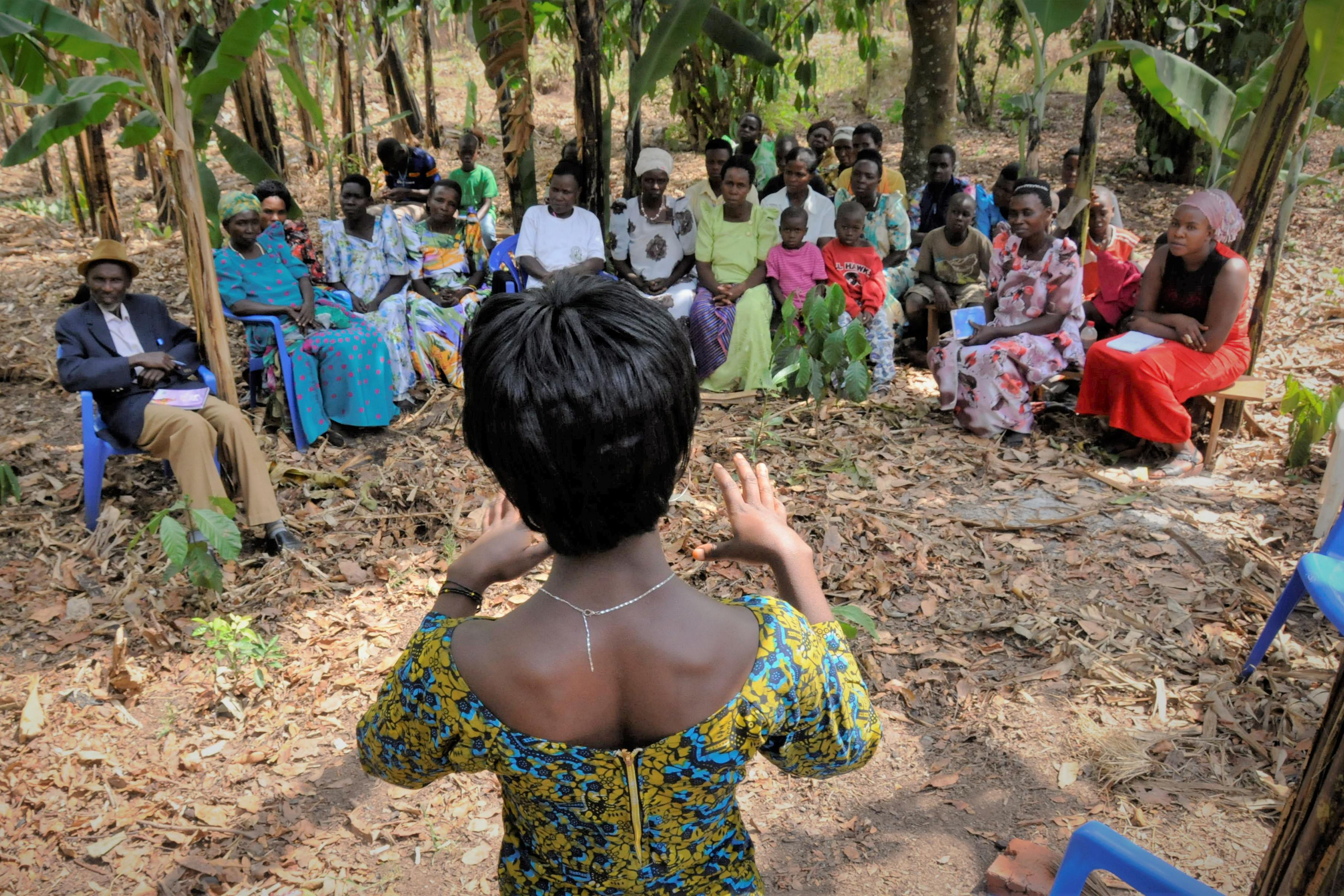 En kvinde underviser en gruppe landmænd i Uganda