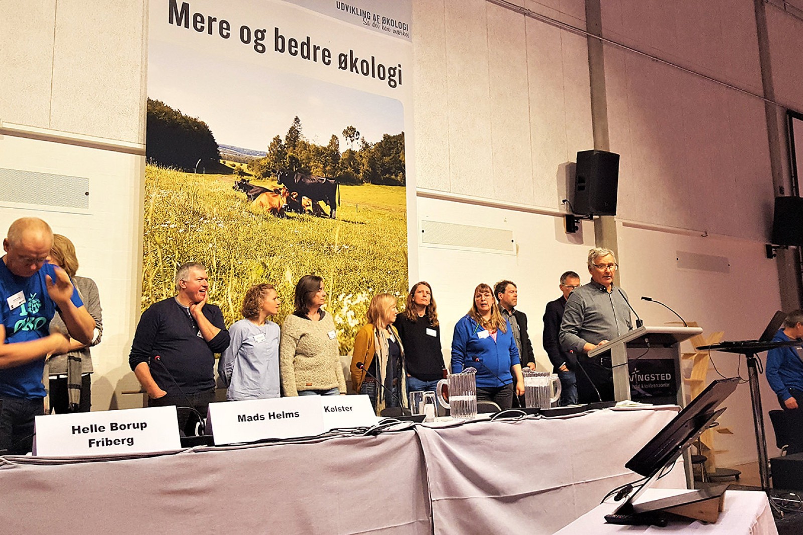 Bestyrelsesmedlemmer i ØL står på en række - foran dem står formand Per Kølster på talerstolen