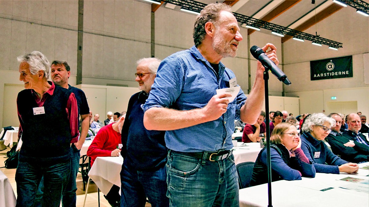 Folk står i kø ved en mikrofon for at stille spørgsmål