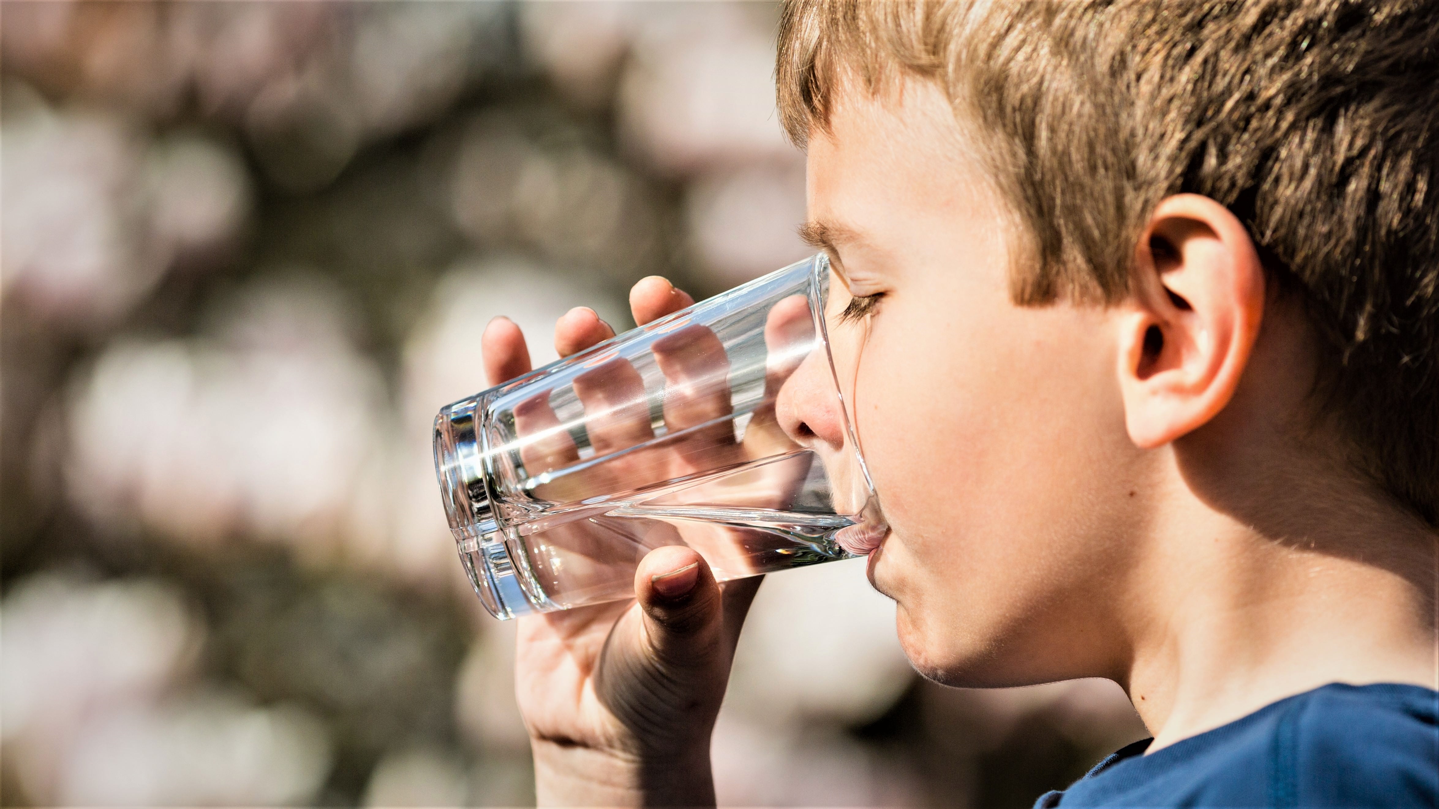 En dreng drikker vand af et glas