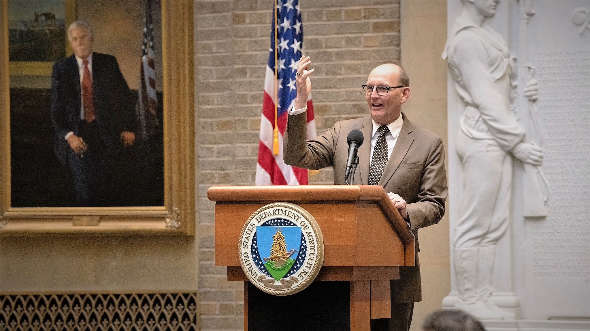 Greg Ibach, undersekretær for USDA, det amerikanske landbrugsministerium, står på podiet og holder tale