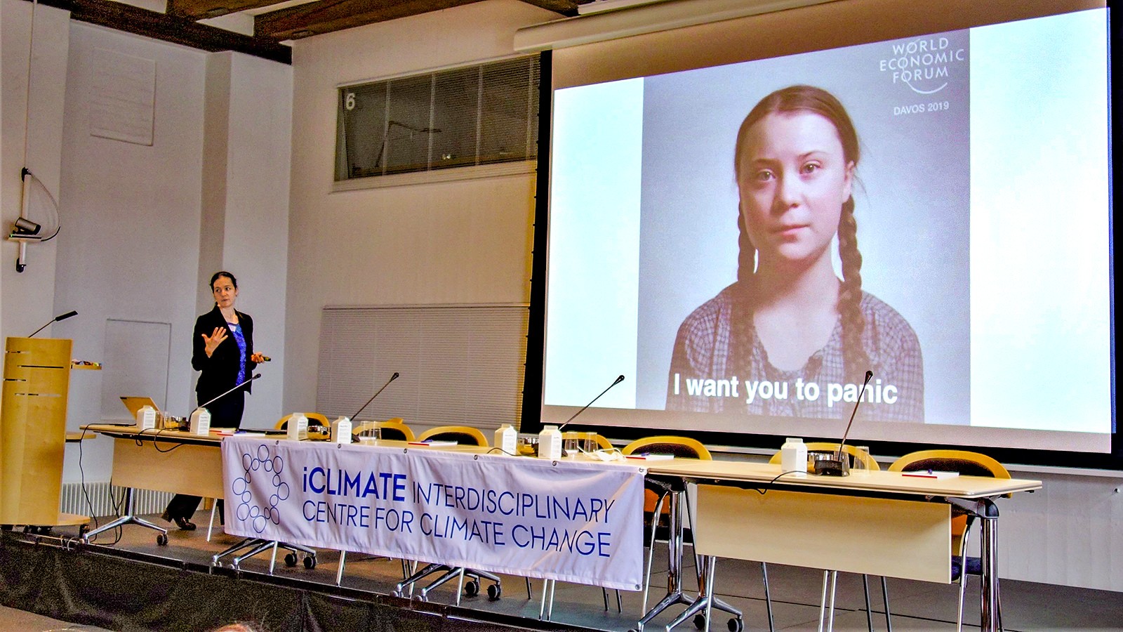 Jessica A. Witzel, professor ved Institut for Virksomhedsledelse på AU viser et stort billede af den svenske klimaaktivist Greta Thunberg med teksten