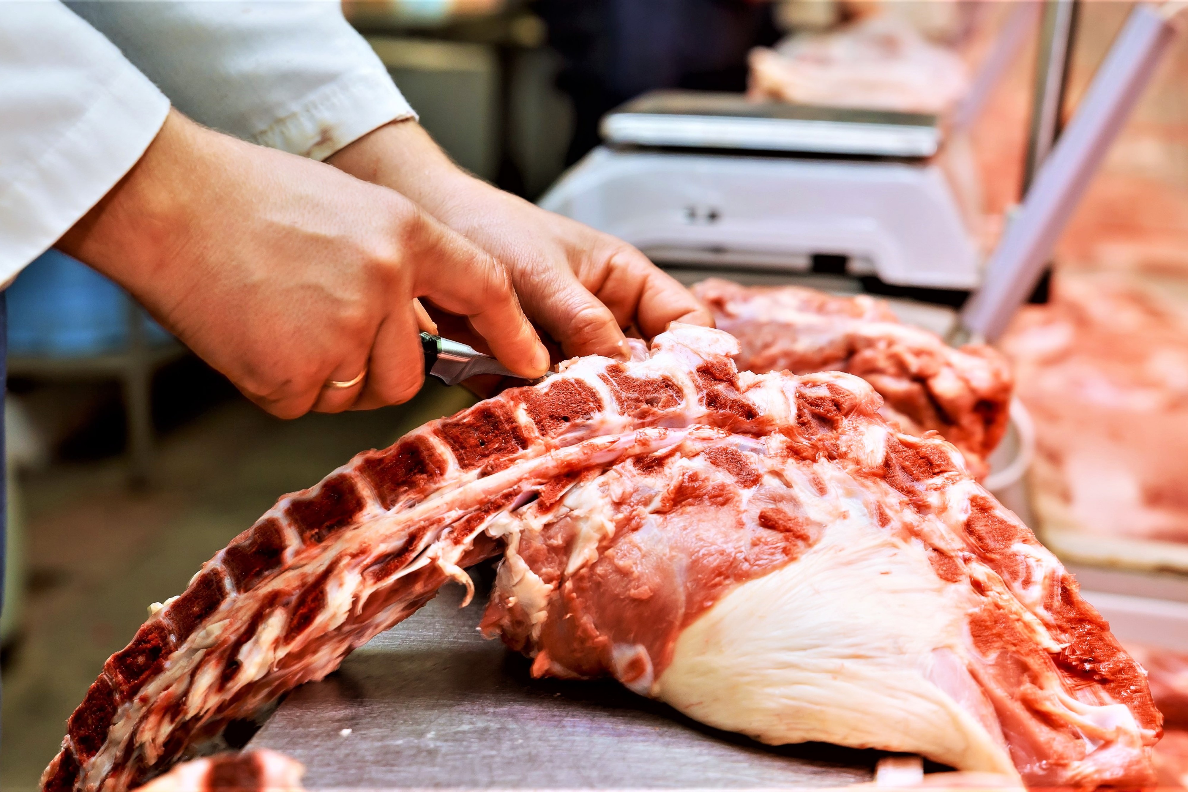 En slagter er ved at skære kød ud
