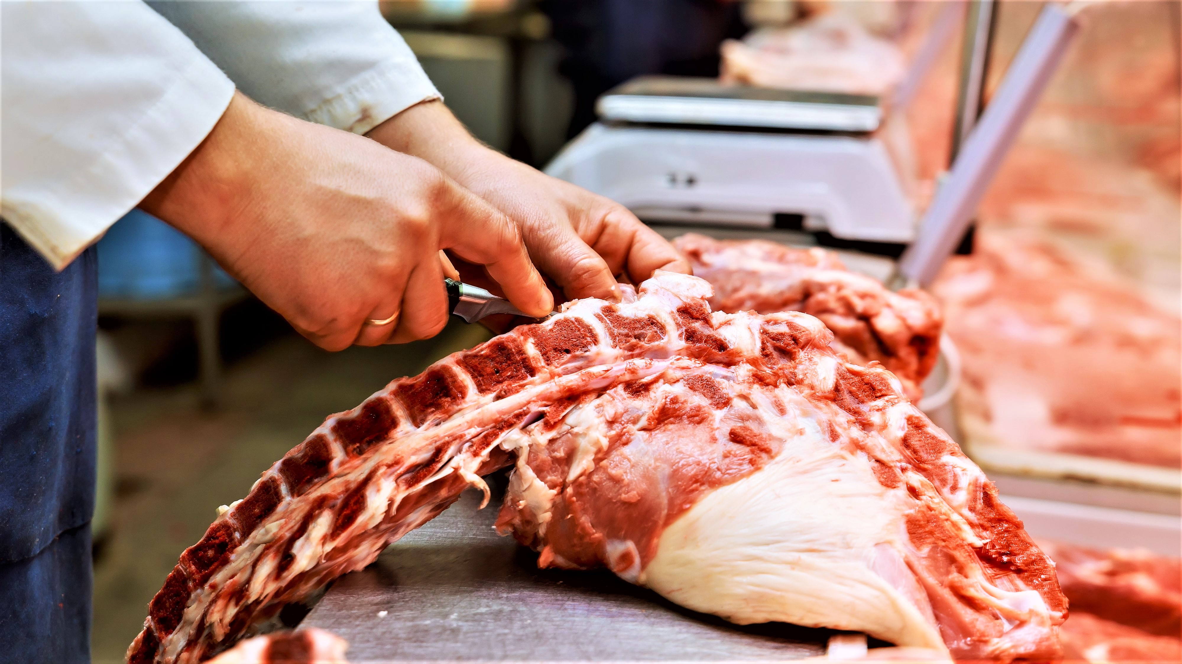 En slagter er ved at skære kød ud