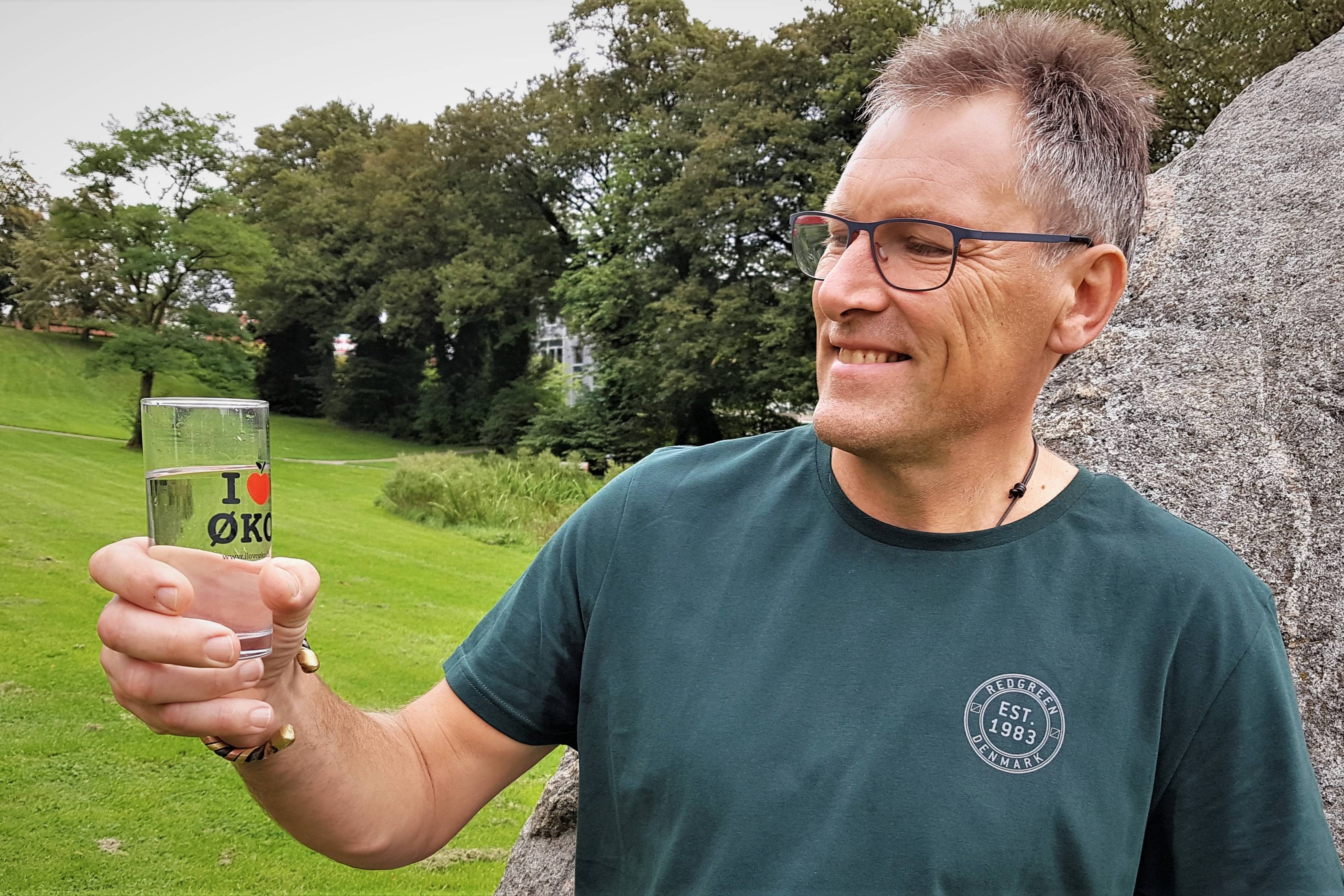 Kim Qvist med et glas rent vand i hånden