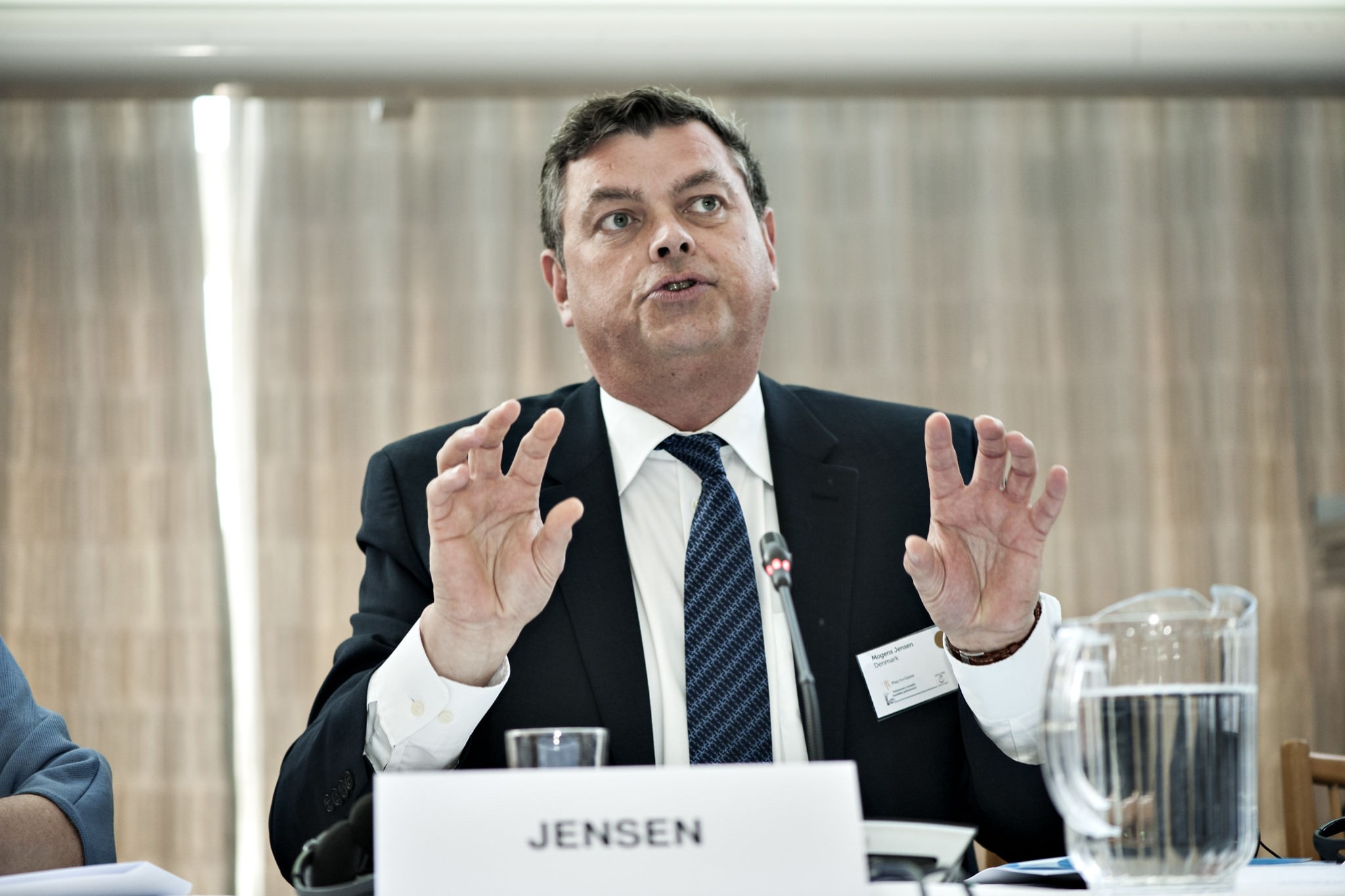 Mogens Jensen sidder ved et bord og taler