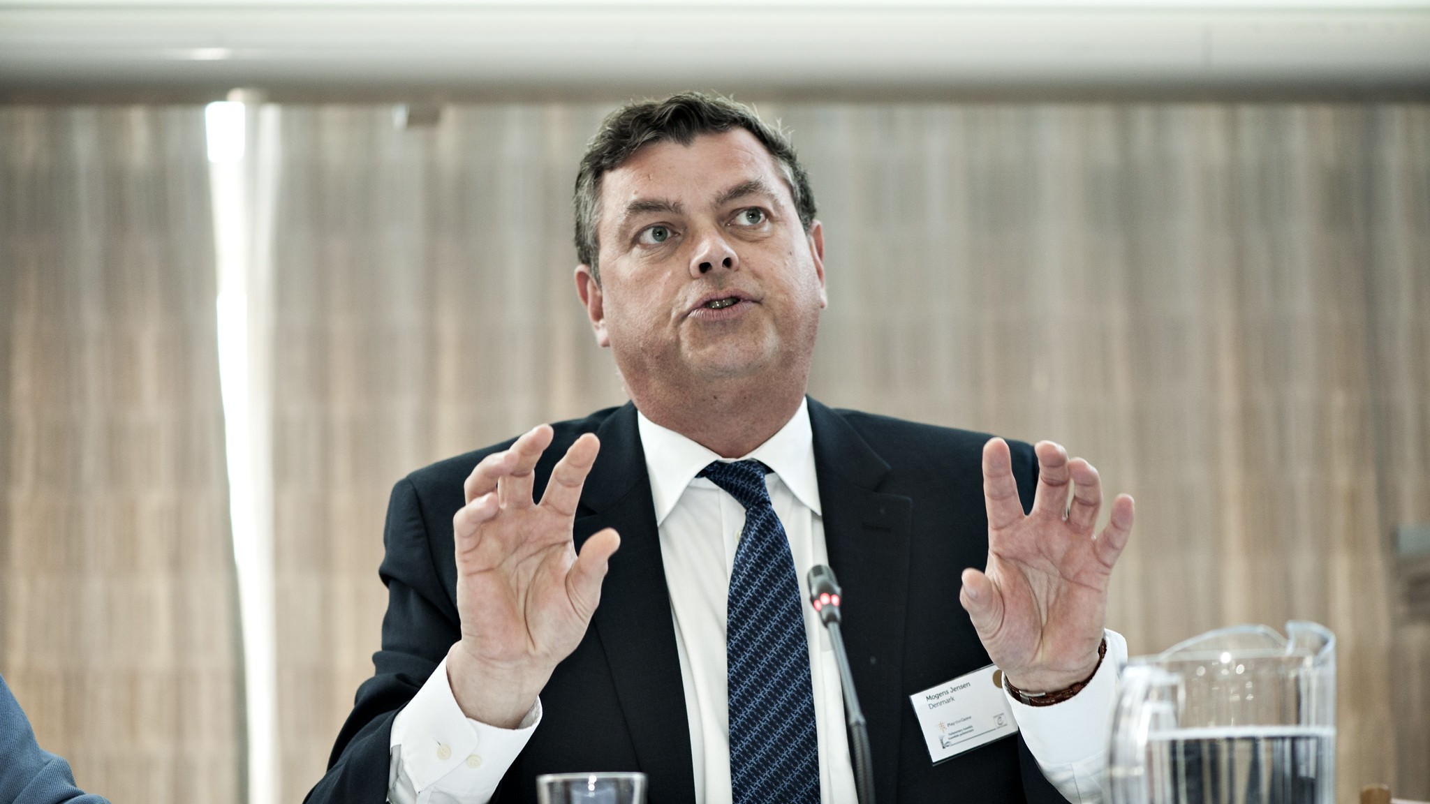 Mogens Jensen sidder ved et bord og taler