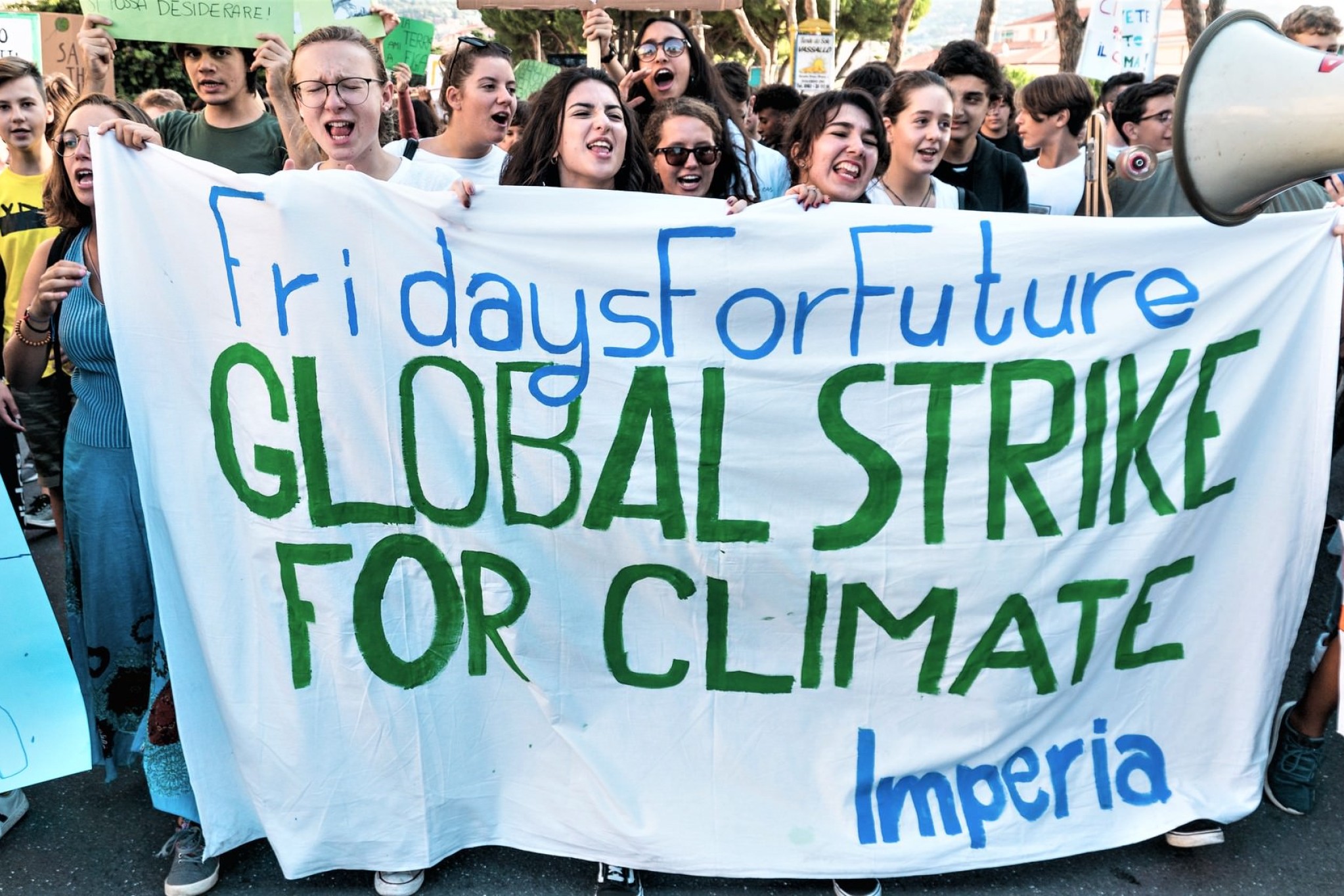 Demonstranter holder et stort banner op med teksten