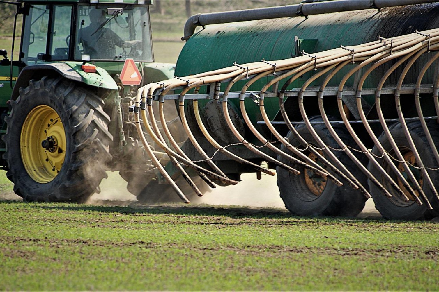 En traktor spreder gødning på marken