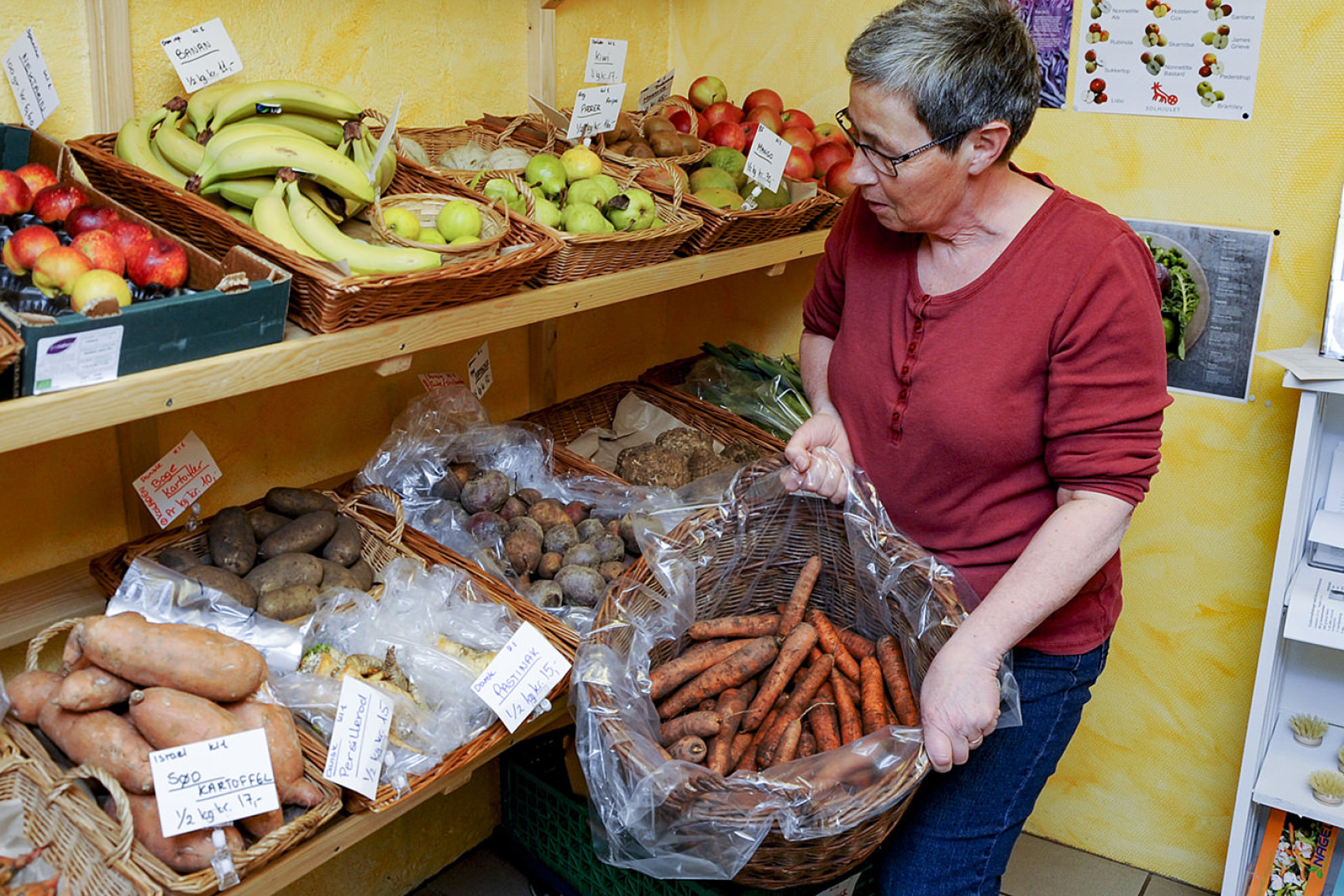 Britta Pedersen med en kurv friskopgravede gulerødder i gårdbutikken