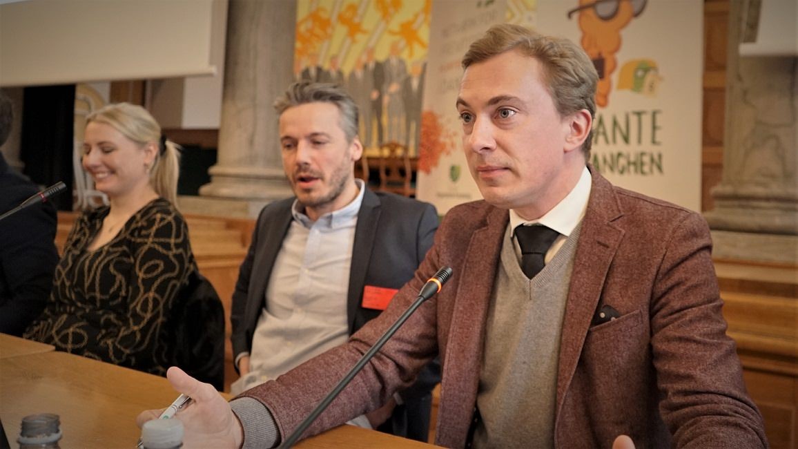 Morten Messerschmidt sidder i et debatpanel og taler ind i en mikrofon