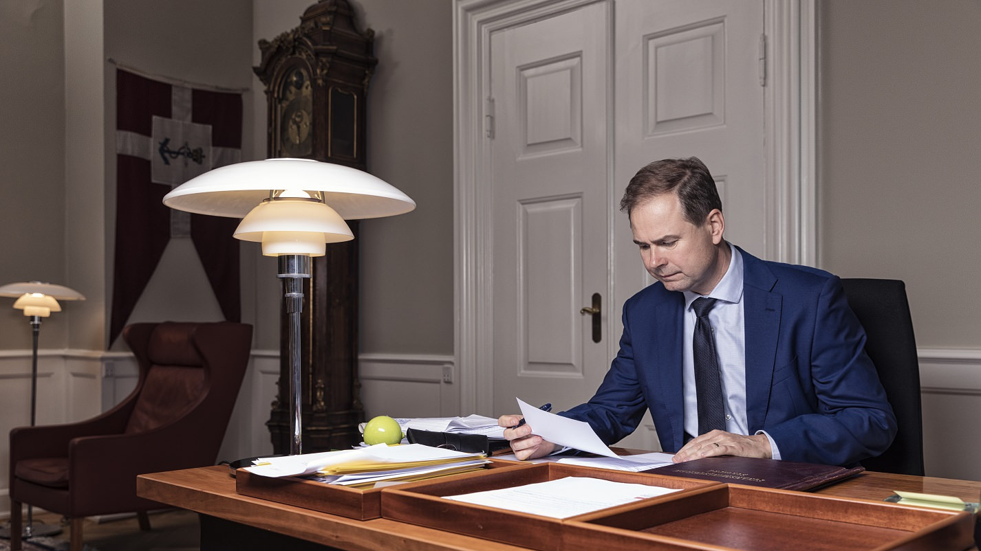 Finansminister Nicolai Wammen sidder ved sit skrivebord og læser et stykke papir