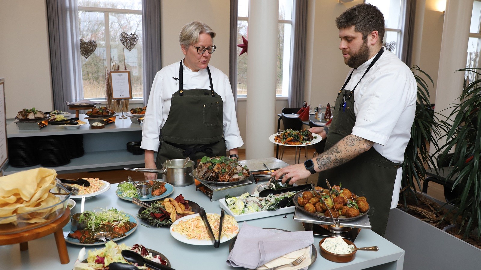 Køkkenchef Benedikte Overby, og souschef Rasmus Kristensen anretter de de sidste fade, inden dagens gæster myldrer ind til frokostbuffeten