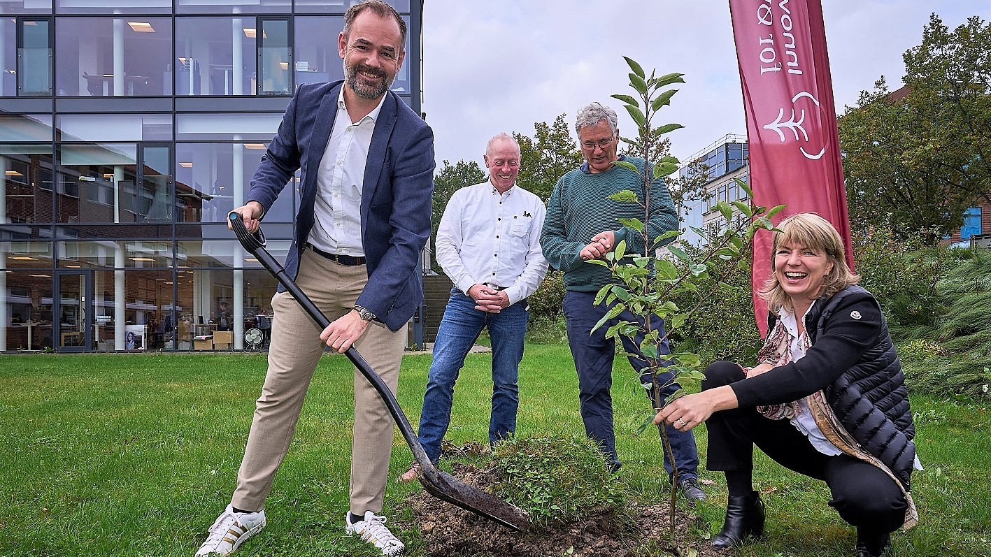 Jacob Bundsgaard, Hans Erik Jørgensen, Per Kølster og Helle Borup Friberg er ved at plante et æbletræ
