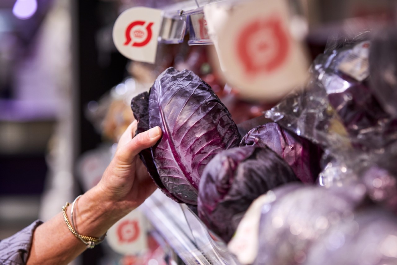 Kunde tager økologisk kål fra butikshylde.