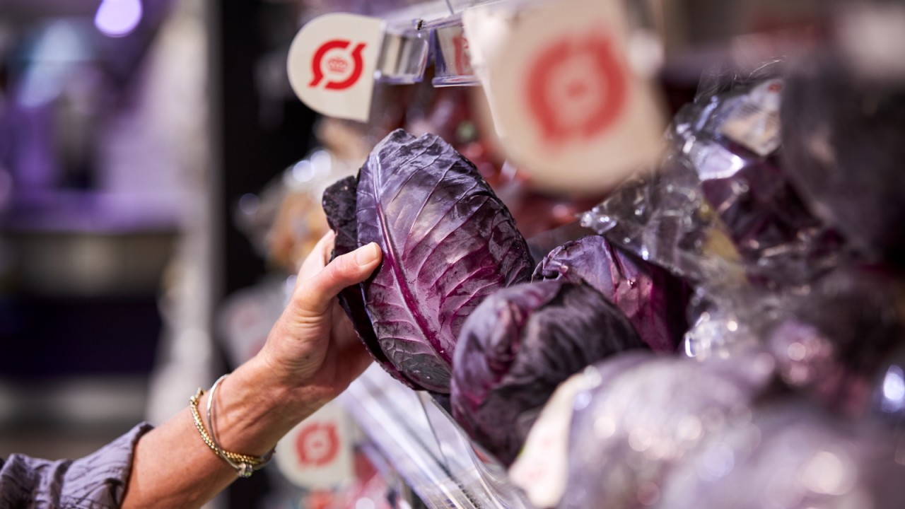 Kunde tager økologisk kål fra butikshylde.