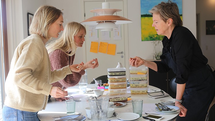 Tre kvinder smager forskellige sorter af bælgplanter