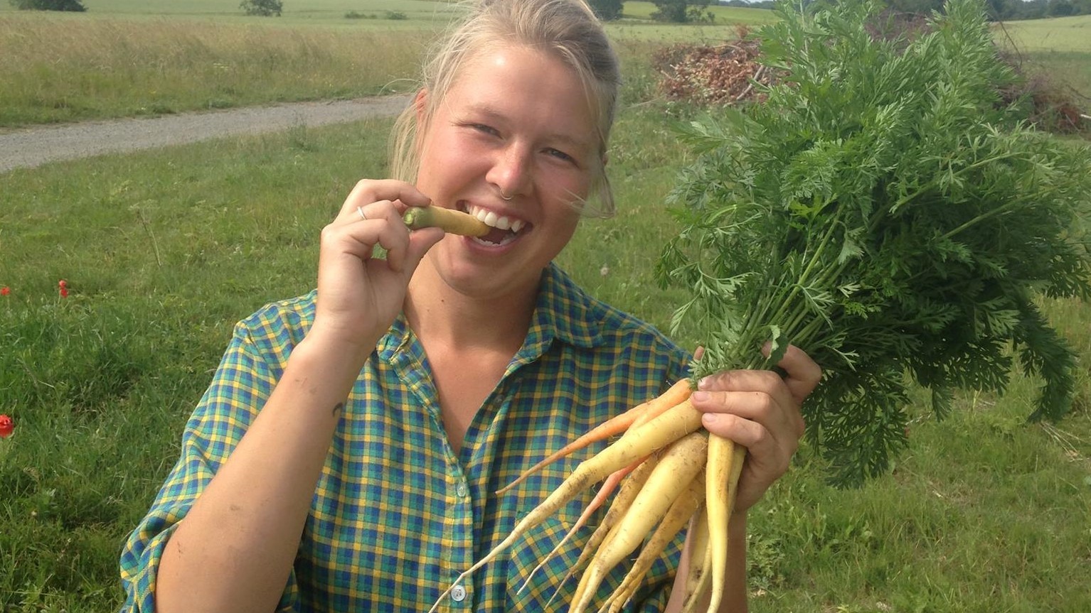 Emilie Ulrik-Petersen med et bundt hjemmeavlede gulerødder.