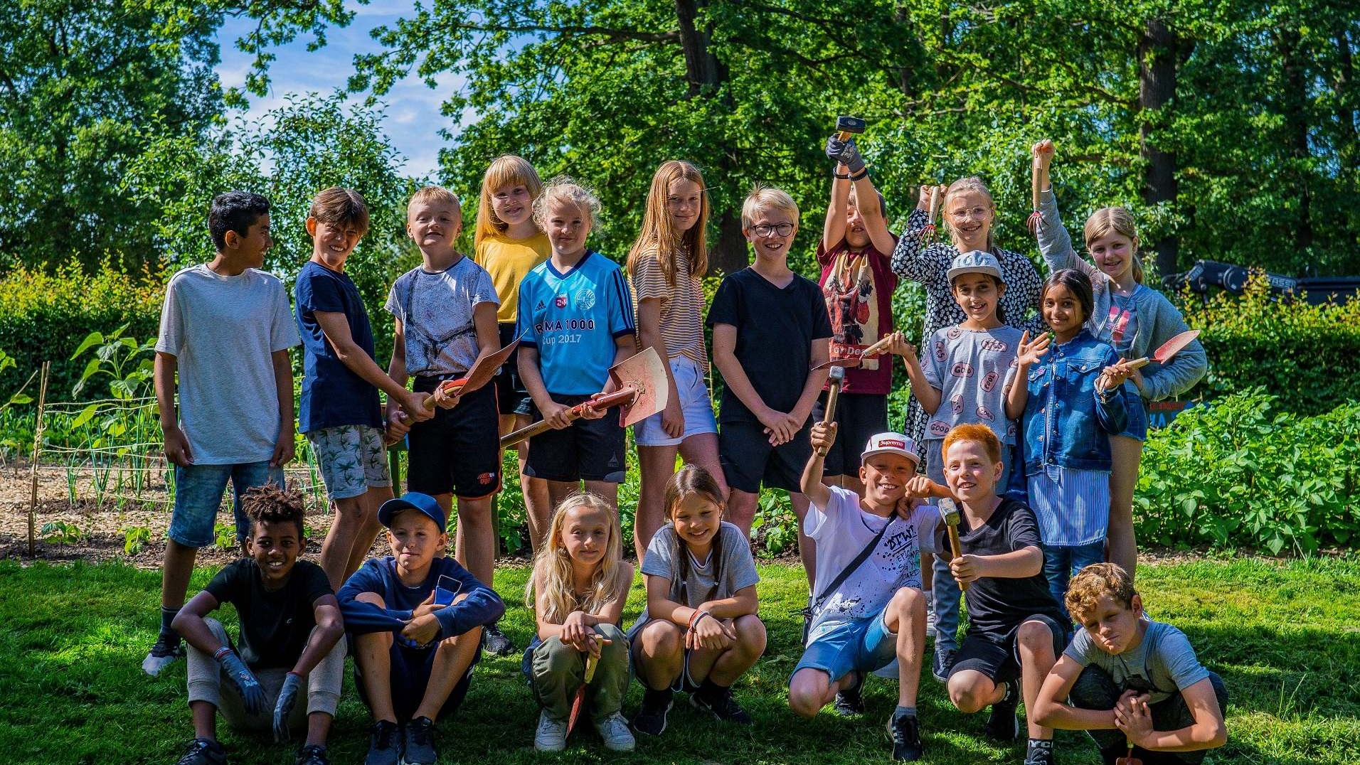 Fællesbillede af skolebørn i en have