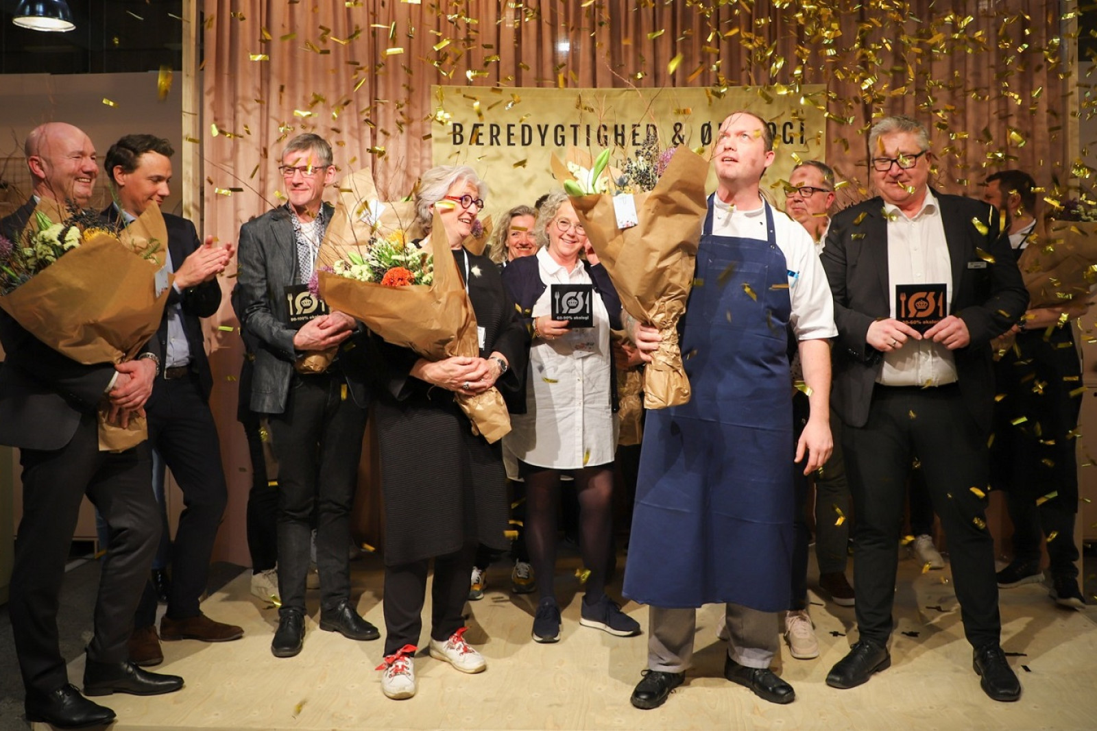 Guldkonfetti drysser ned over de ansatte fra køkkenerne, som bliver hyldet på scenen på Foodexpo