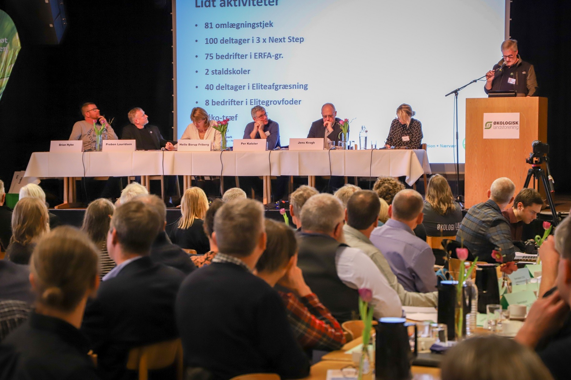 Tilhørere til Økologisk Landsforenings generalforsamling lytter til en taler