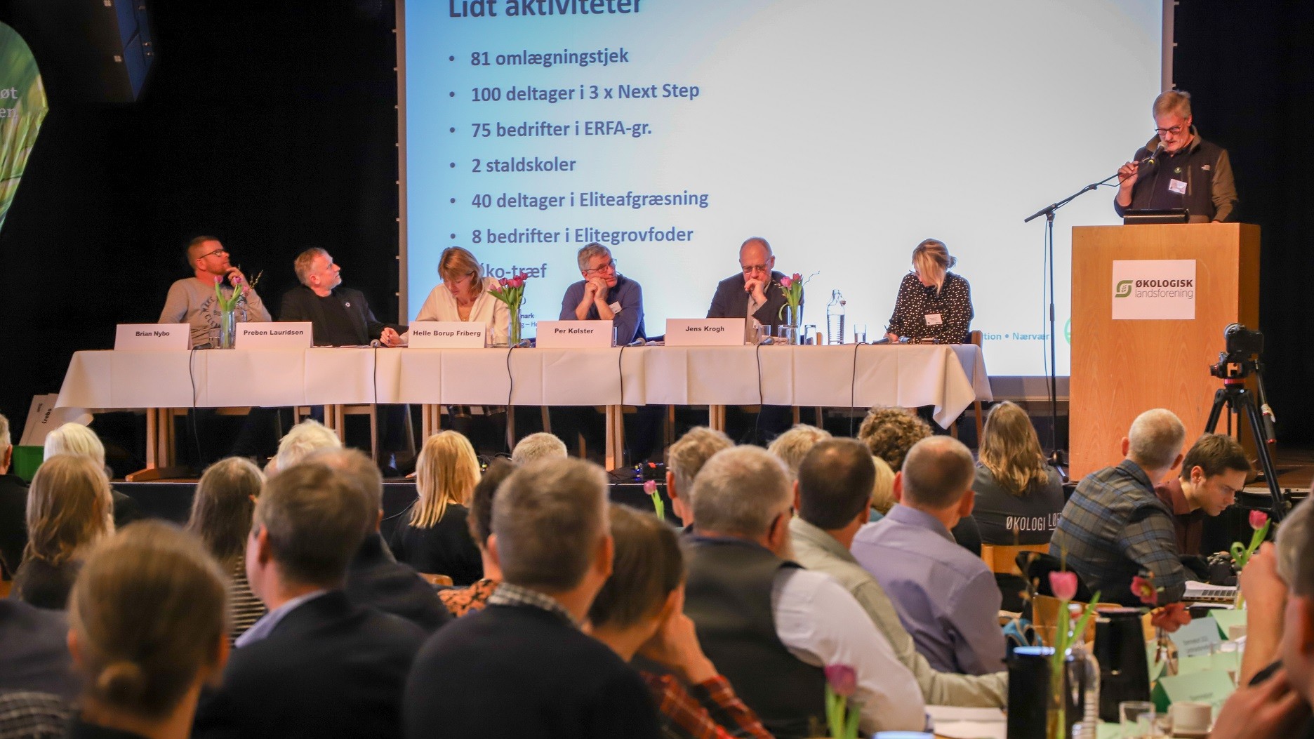 Tilhørere til Økologisk Landsforenings generalforsamling lytter til en taler