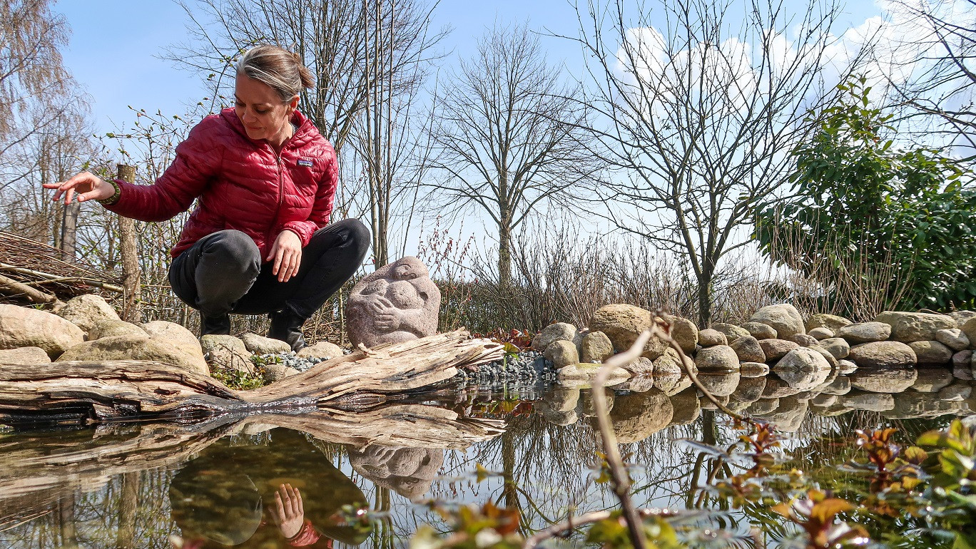 Katrine Turner sidder ved sit vandområde i sin have