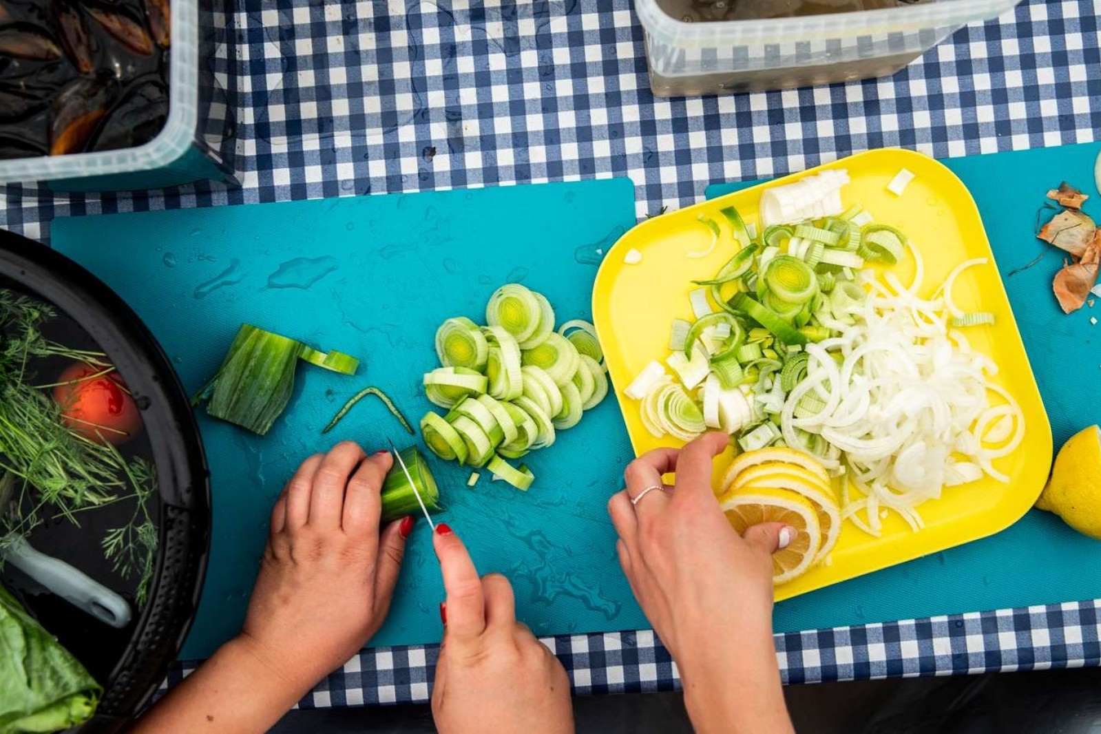 Grønsager skæres på et skærebræt og lægges på en tallerken