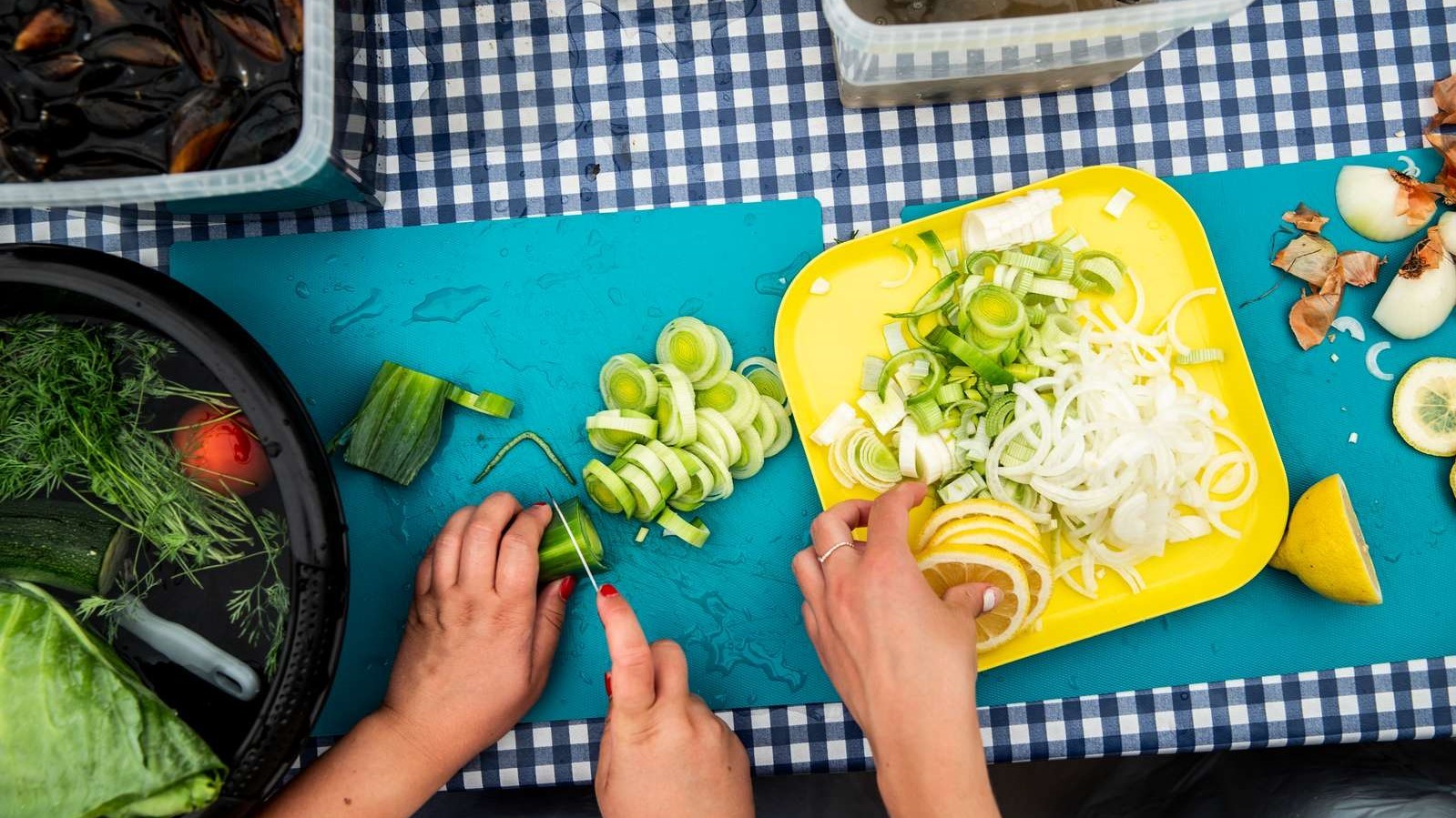 Grønsager skæres på et skærebræt og lægges på en tallerken