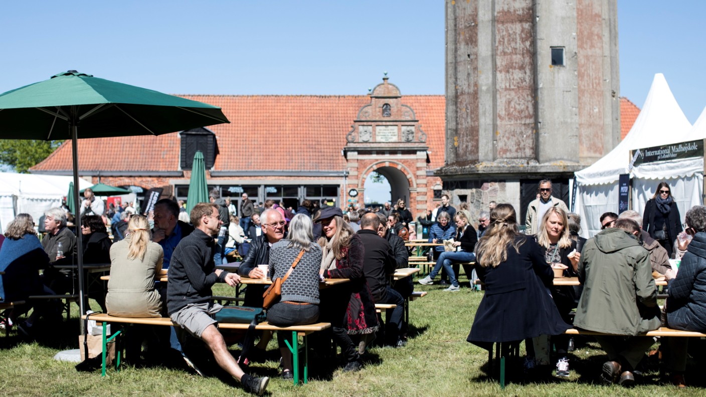 Gæster sidder ude ved borede under Madens Folkemøde 2019