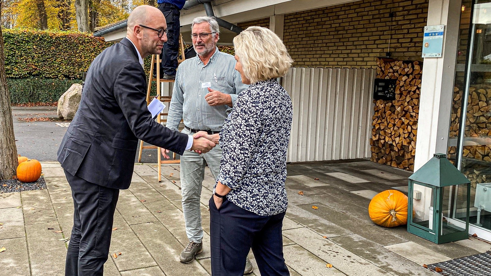 Rasmus Prehn giver hånd til Britta Riis - bag dem står Per Kølster