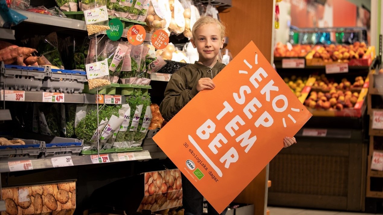 Dreng står i butik med skilt om Eko september