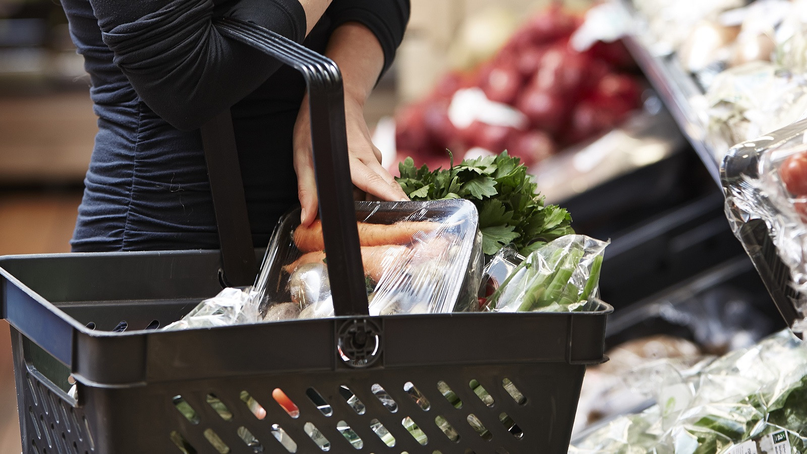 Kunde stopper grøntsager i indkøbskurv