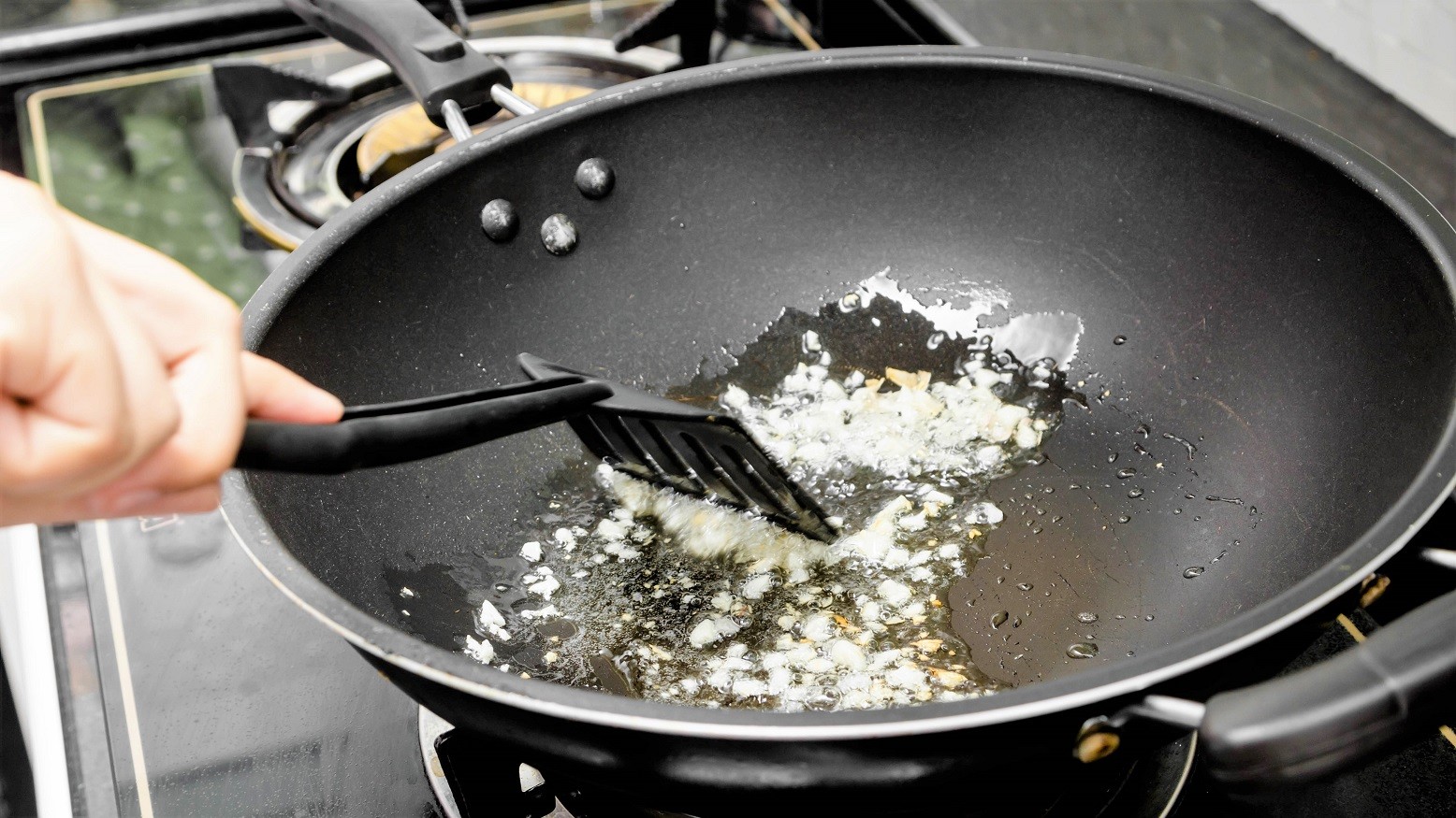 En person er ved at stege løg på en pande